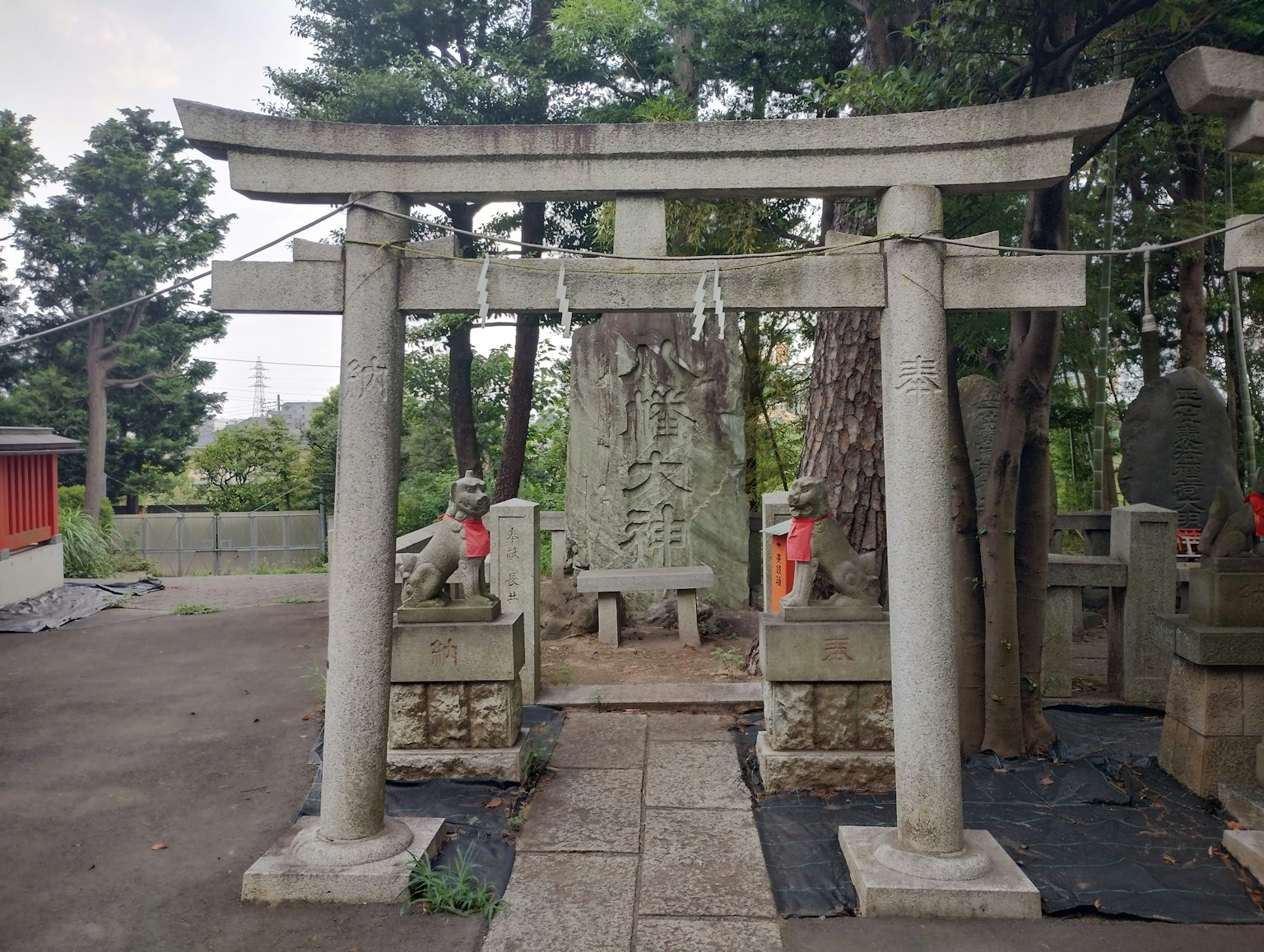 Una vista serena con un torii de santuario y esculturas de piedra