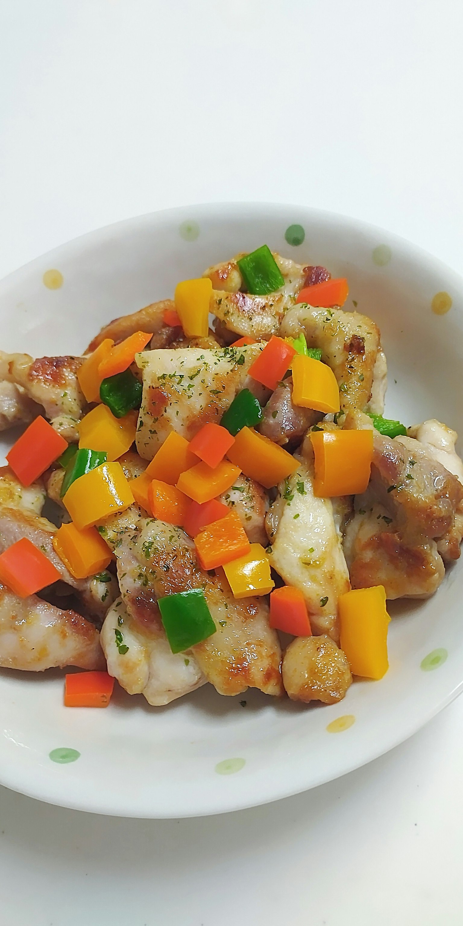 จานสีสันสดใสที่มีไก่และผักหลากหลายชนิด