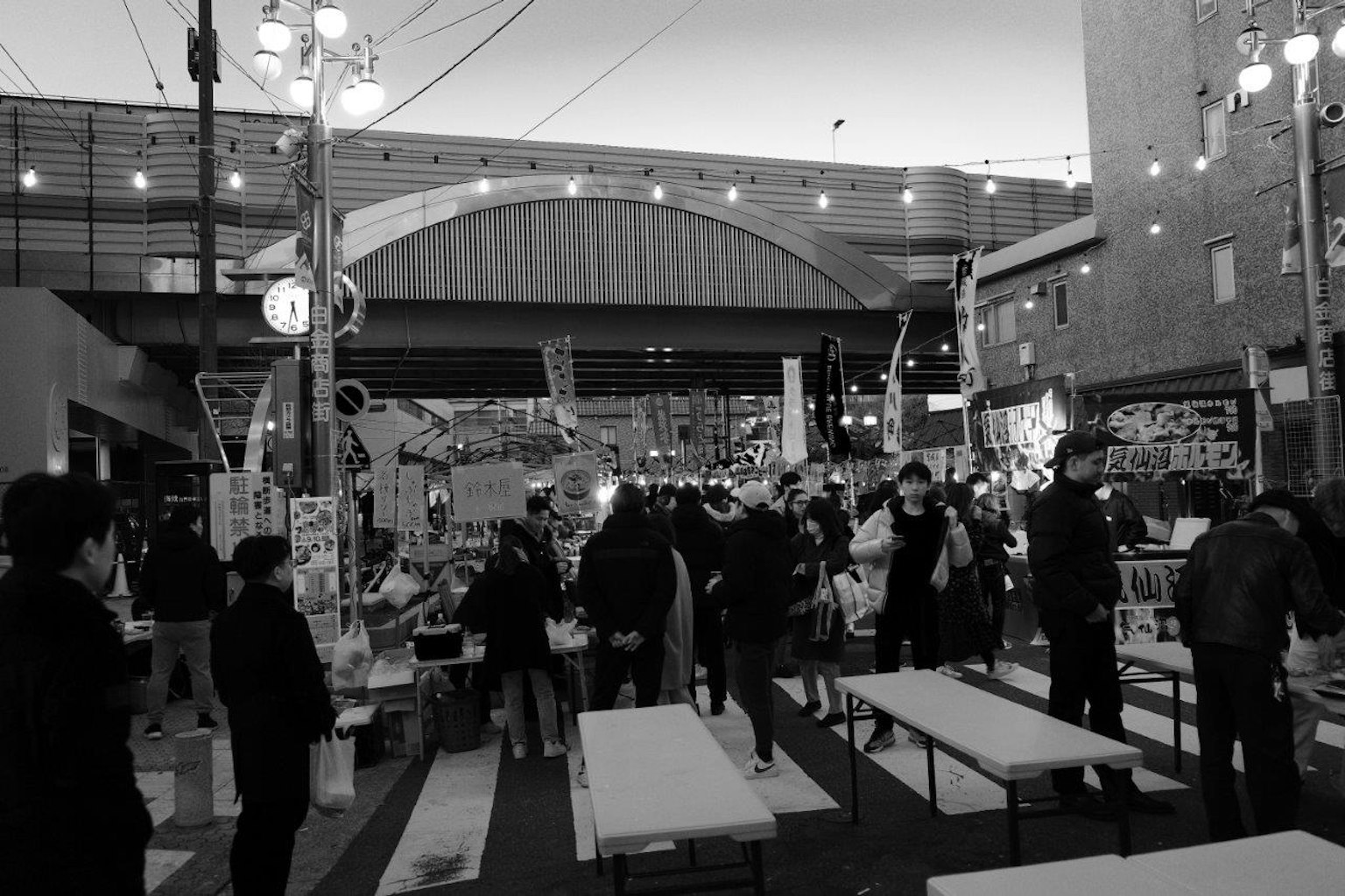 Busy outdoor market scene with people gathered and tables set up