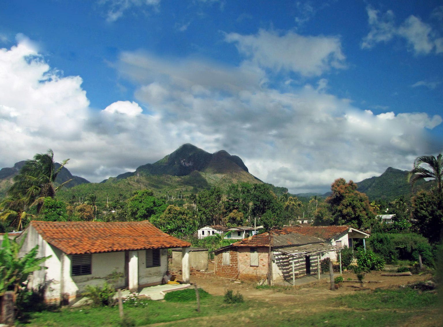 Paisaje rural con casas rodeadas de montañas