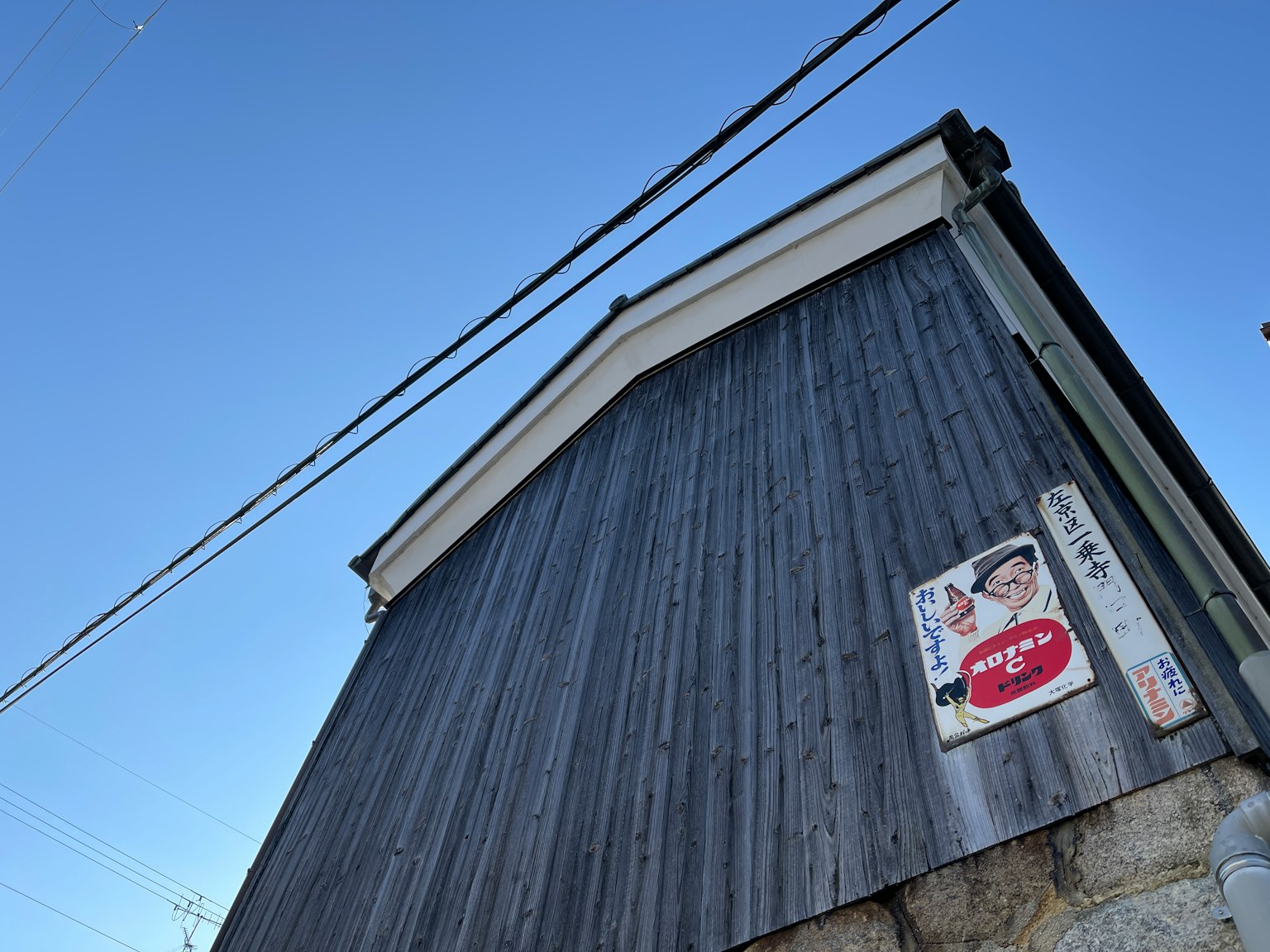 Bâtiment avec mur en bois et publicité sous un ciel bleu