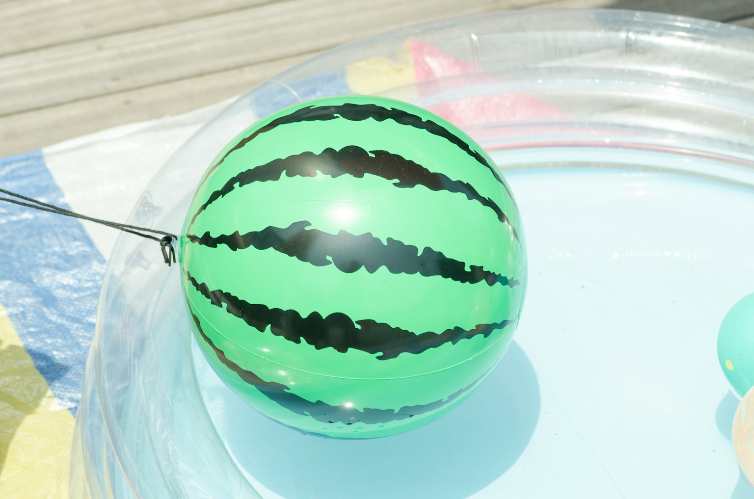 Green watermelon patterned ball floating in water