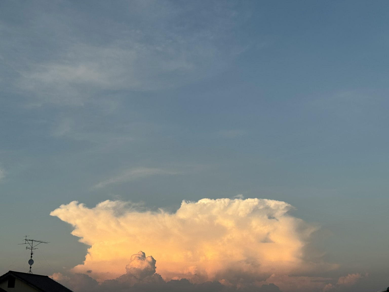 青空に浮かぶ白い雲とオレンジ色の夕焼け