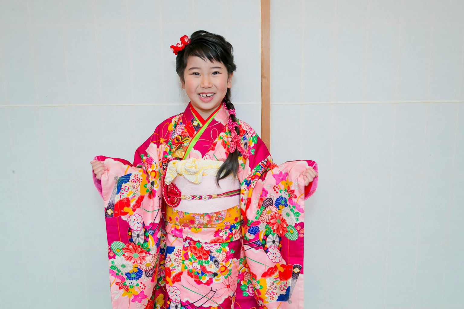 Gadis dalam kimono cerah tersenyum ke arah kamera