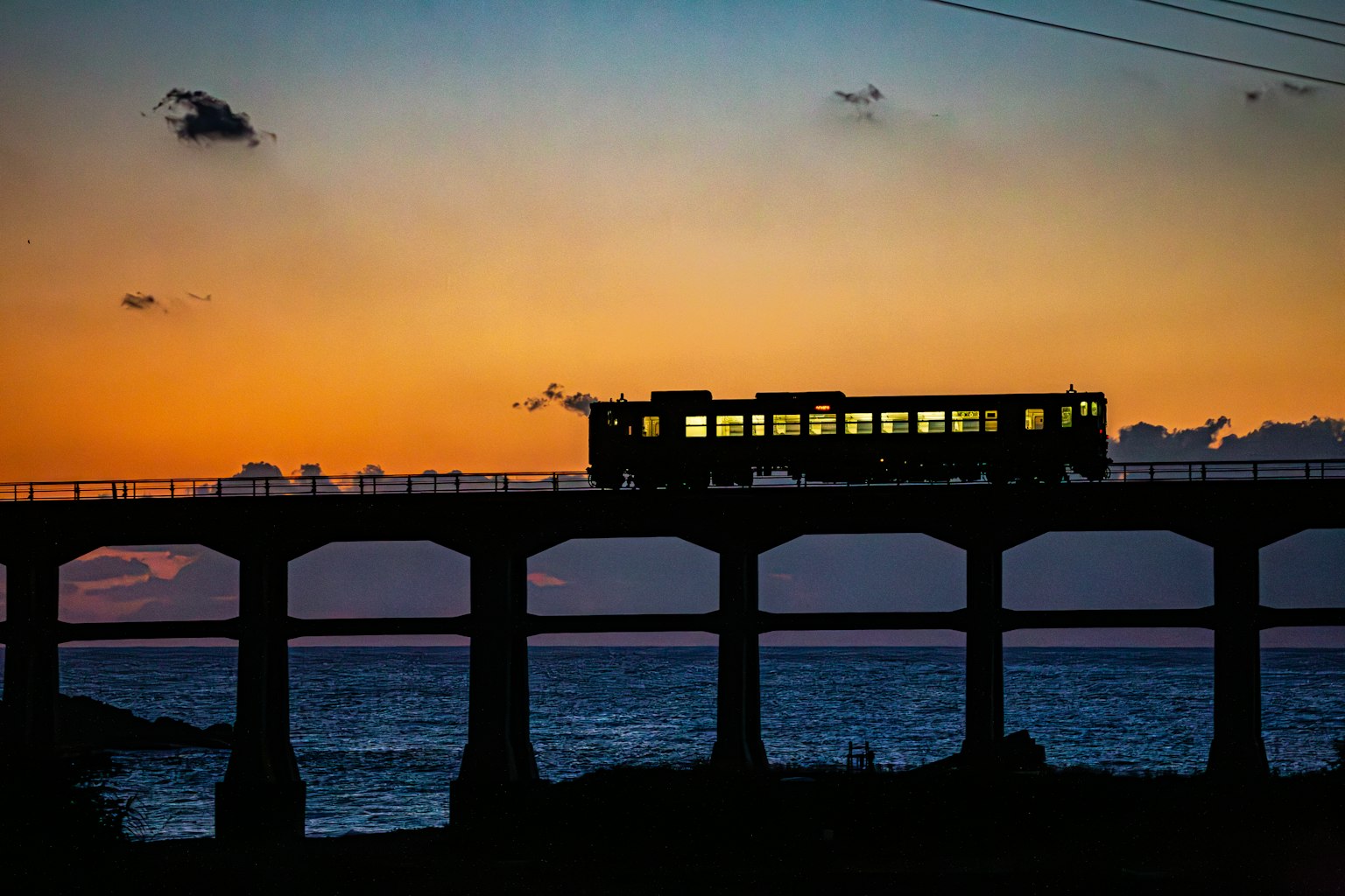 夕陽下橋上行駛的火車輪廓