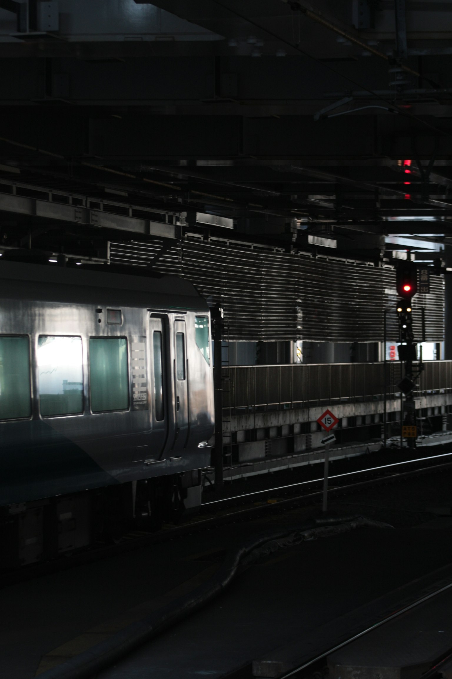 Train arrêté sur une plateforme de gare sombre avec des feux de signalisation