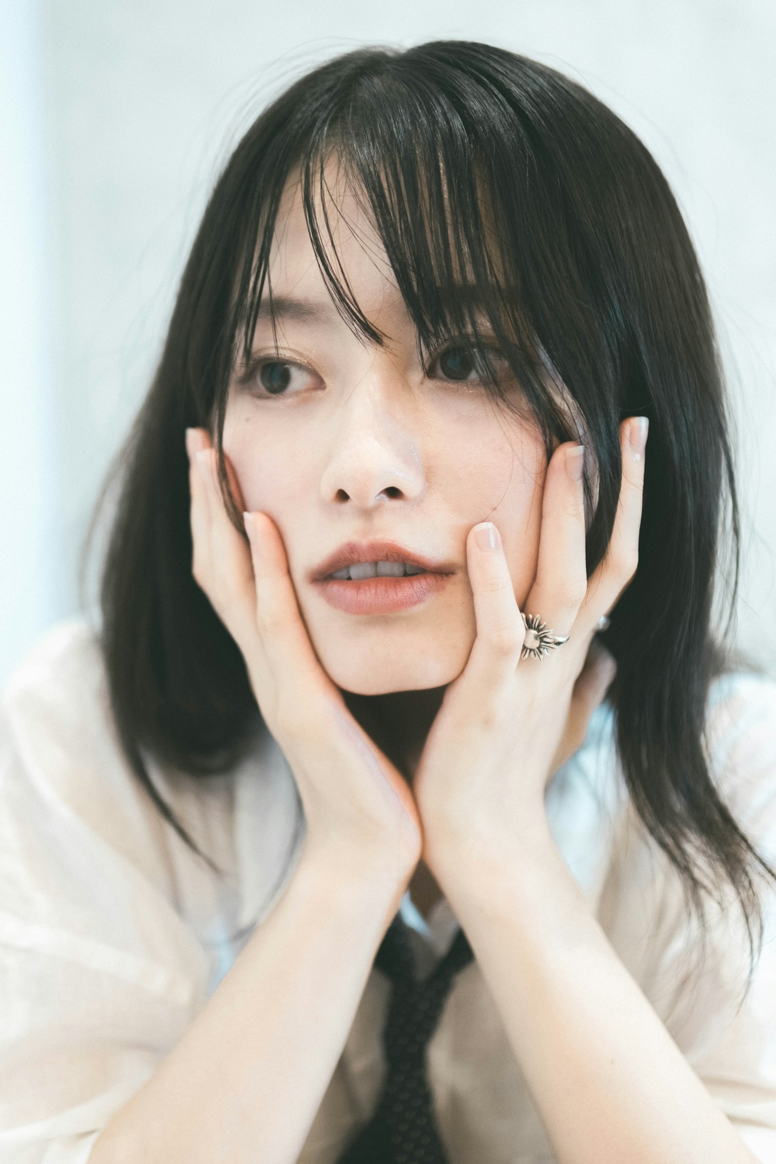年轻女性用手托着脸，表情沉思