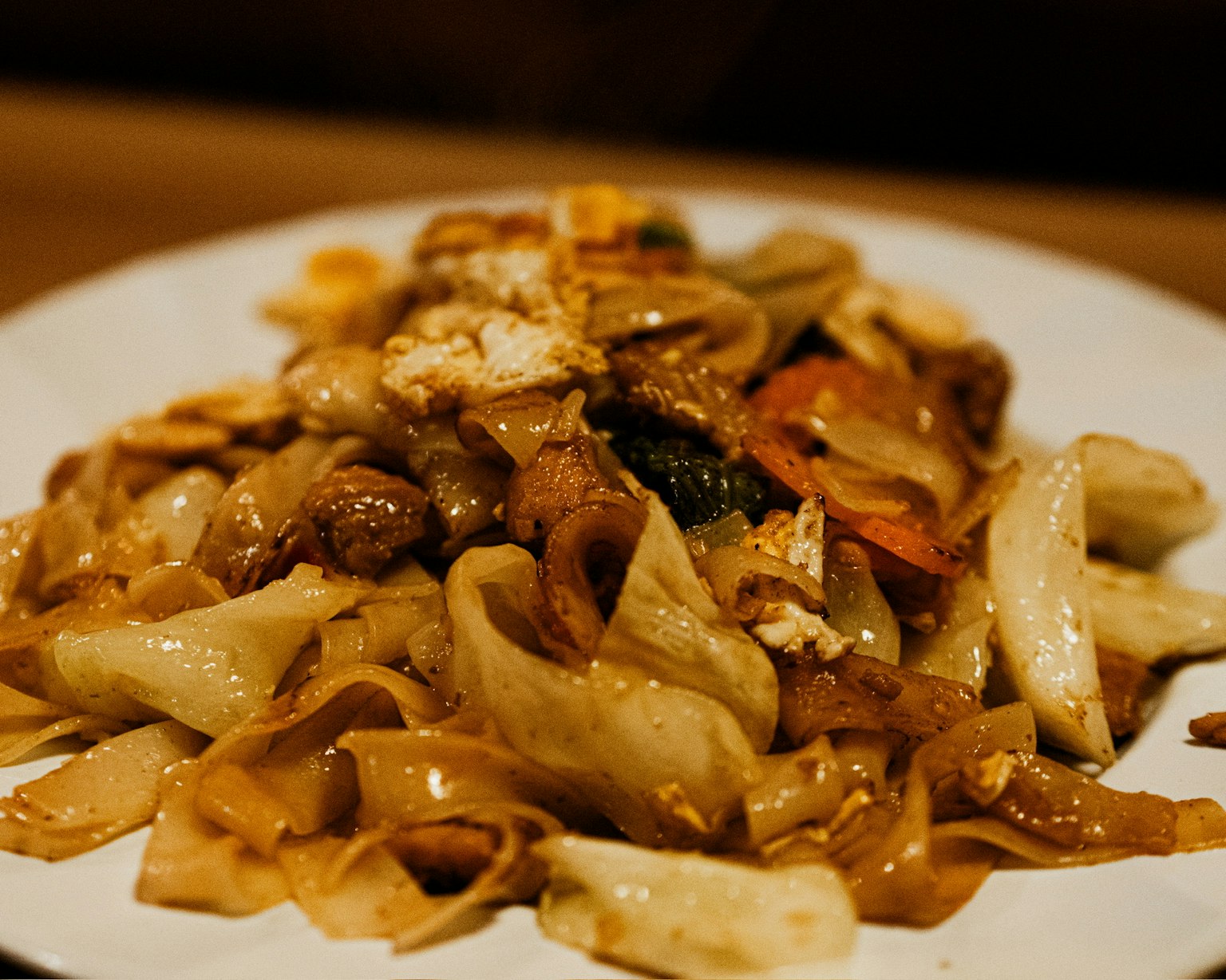 Piring lezat mie goreng dengan sayuran dan ayam