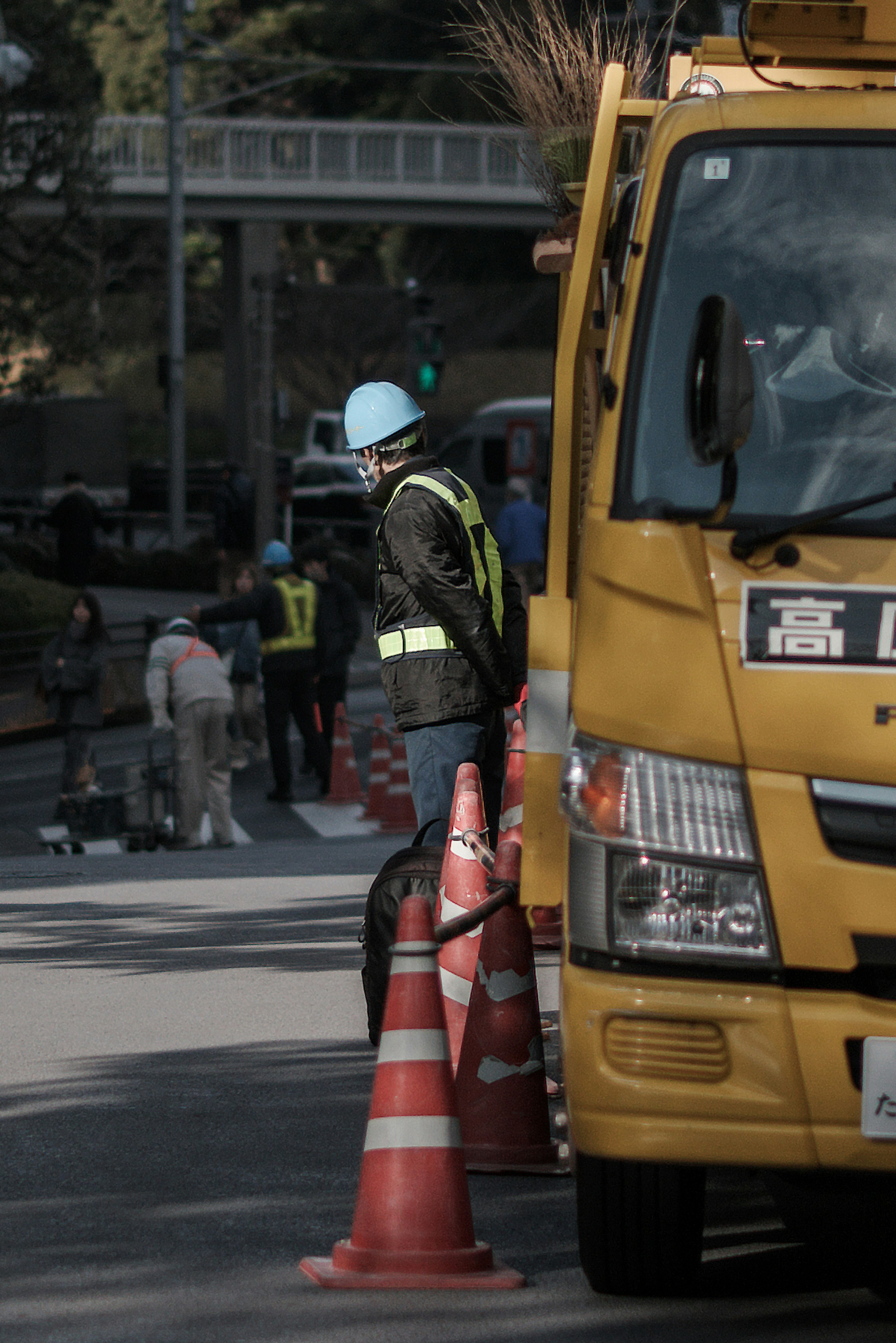 市街地を走るトラックと交通コーンのある道路