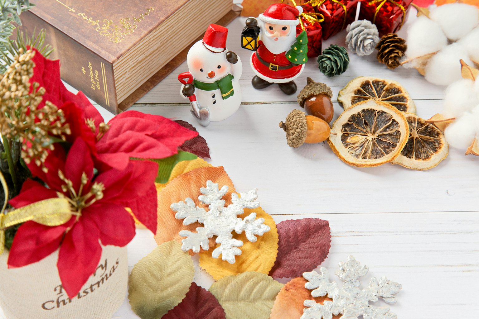 Decoraciones navideñas que incluyen figuras de Santa y flores festivas sobre una mesa