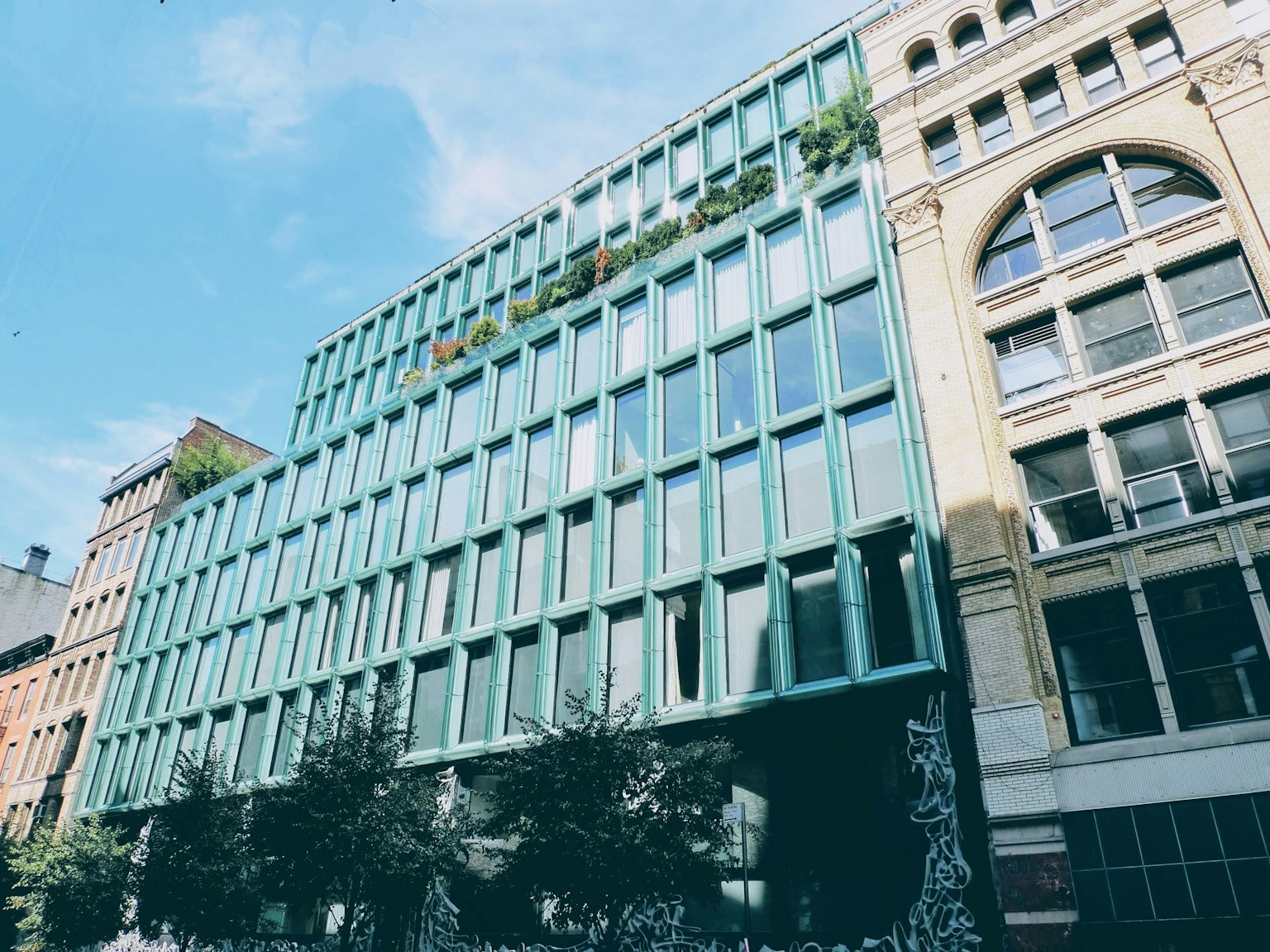 Modern building with glass facade next to historic architecture