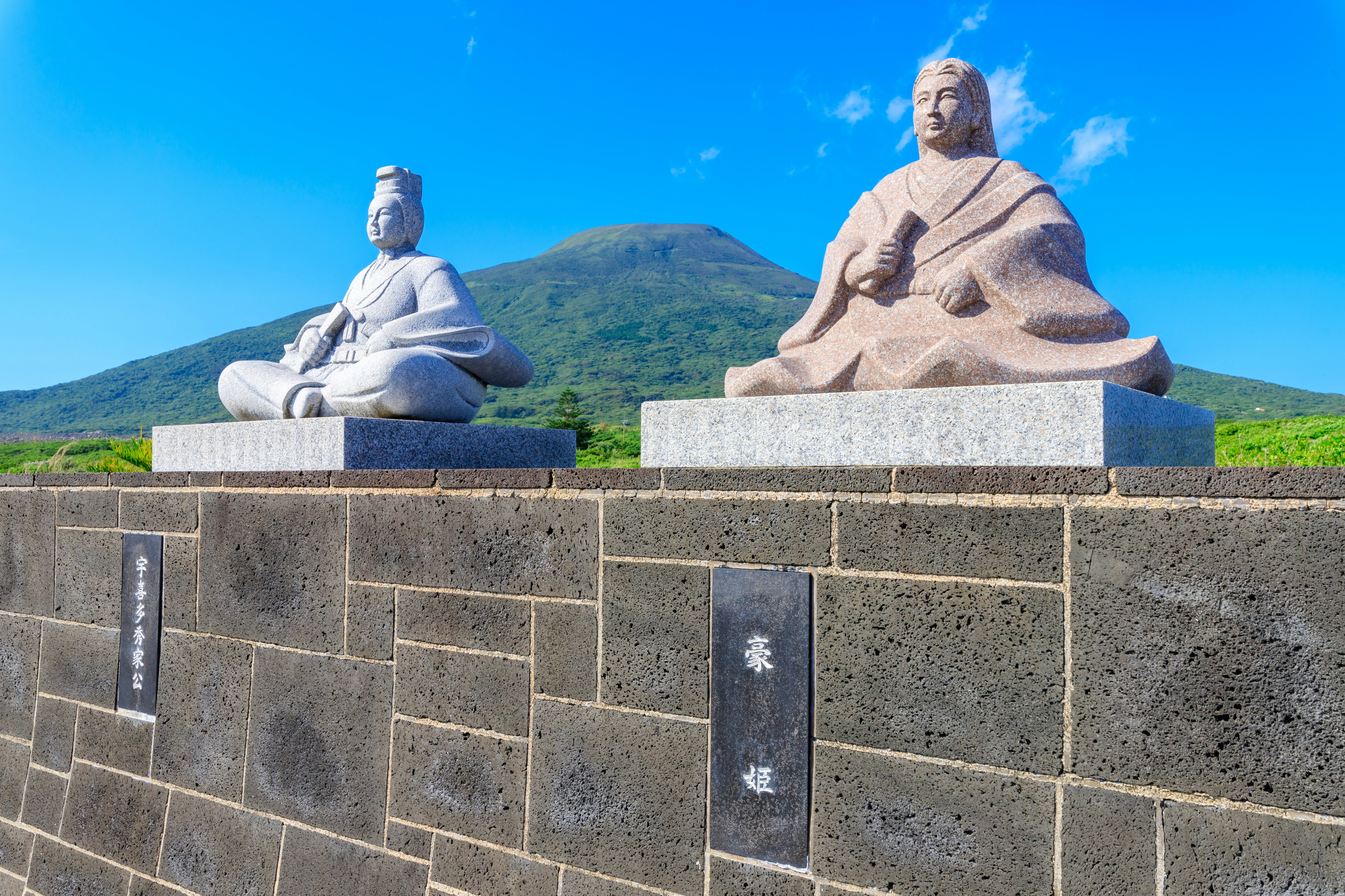 藍天映襯下的山景與石像坐像底座