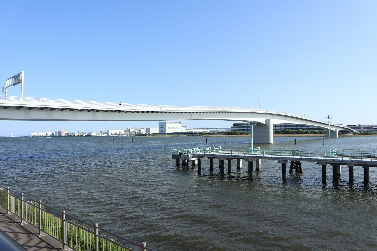 Weißer Brücke, die über Wasser spannt, mit einem Pier darunter