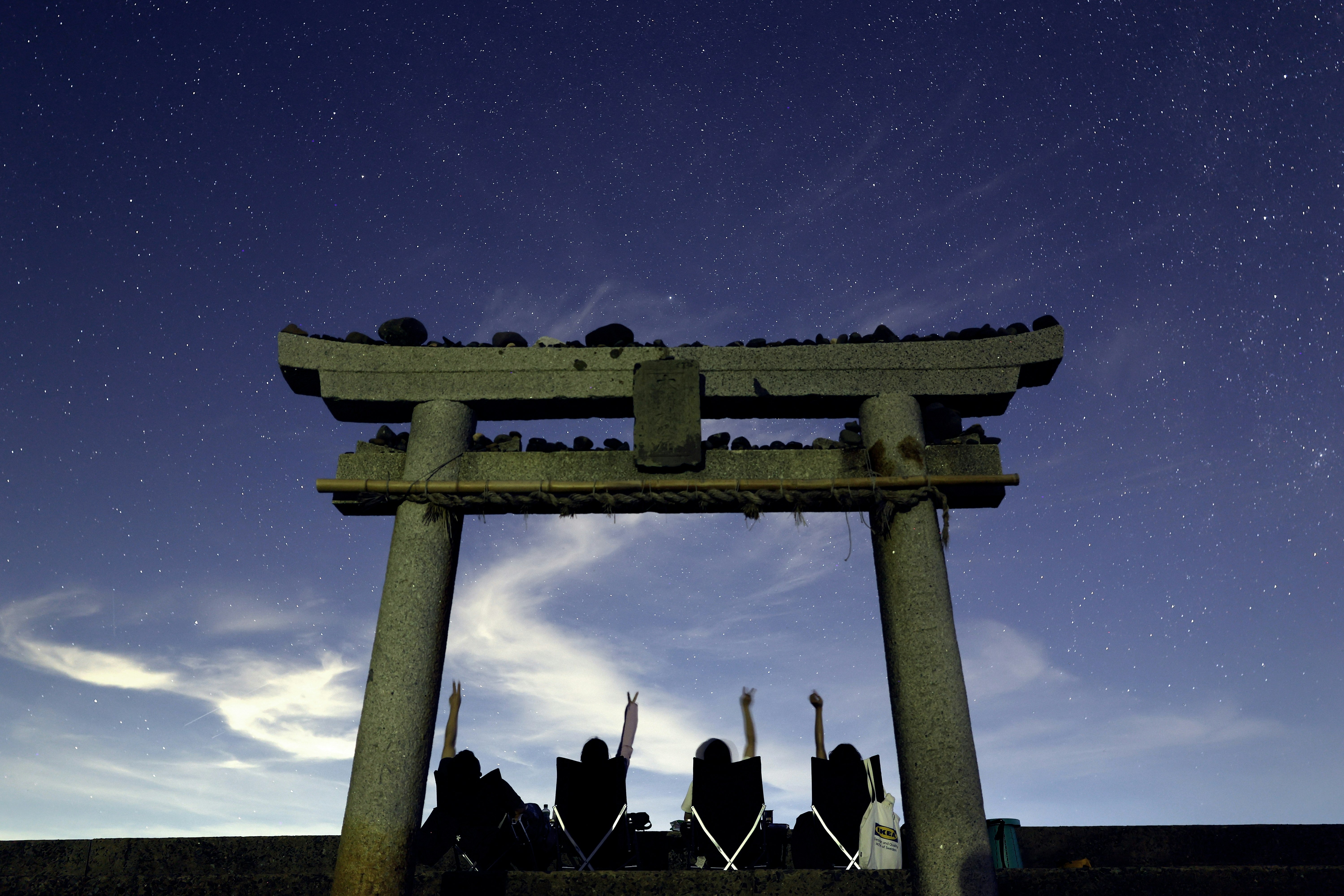 silhouette of a torii gate under a starry night sky
