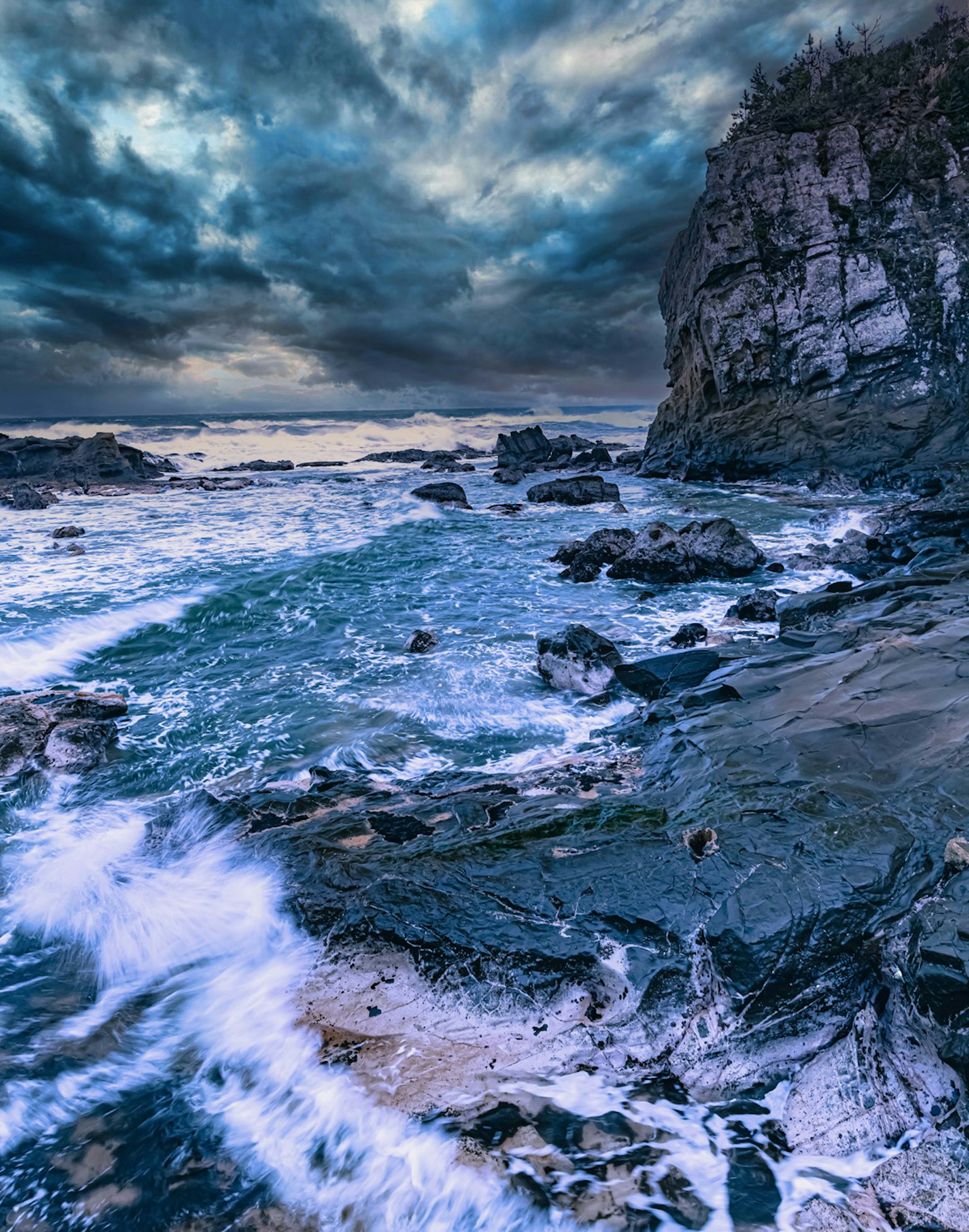 Paisaje costero con olas rompientes y costa rocosa cielo dramático con nubes oscuras