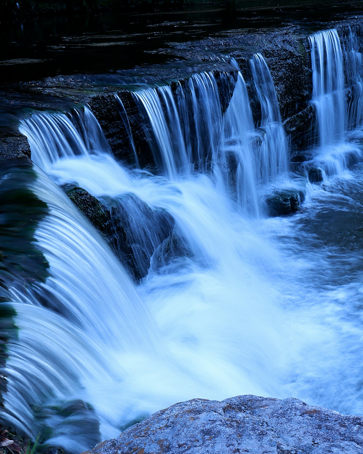 ทัศนียภาพที่สวยงามของน้ำตกที่มีน้ำสีฟ้าไหล