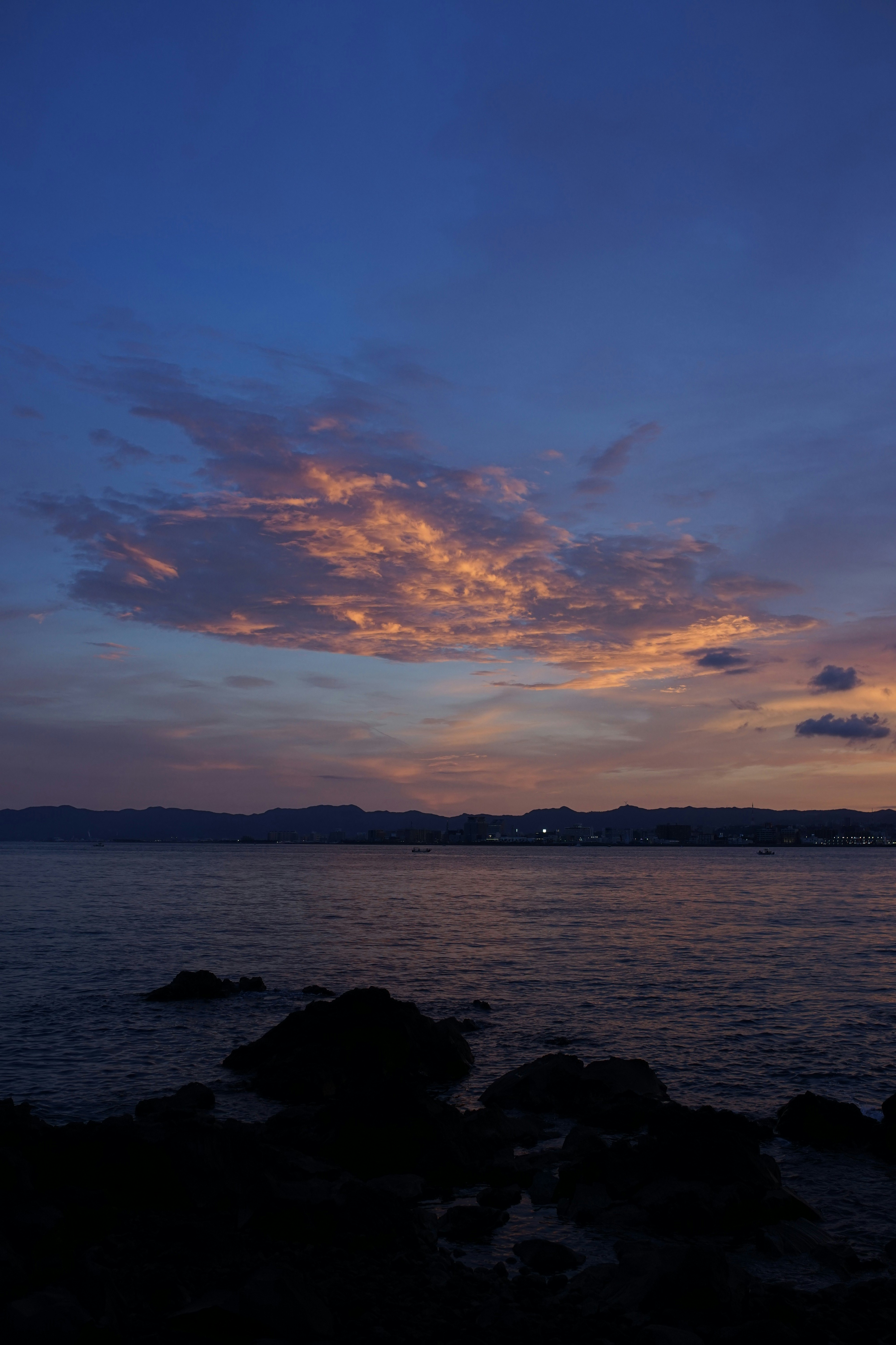 夕暮れの海辺と水平線の雲の空