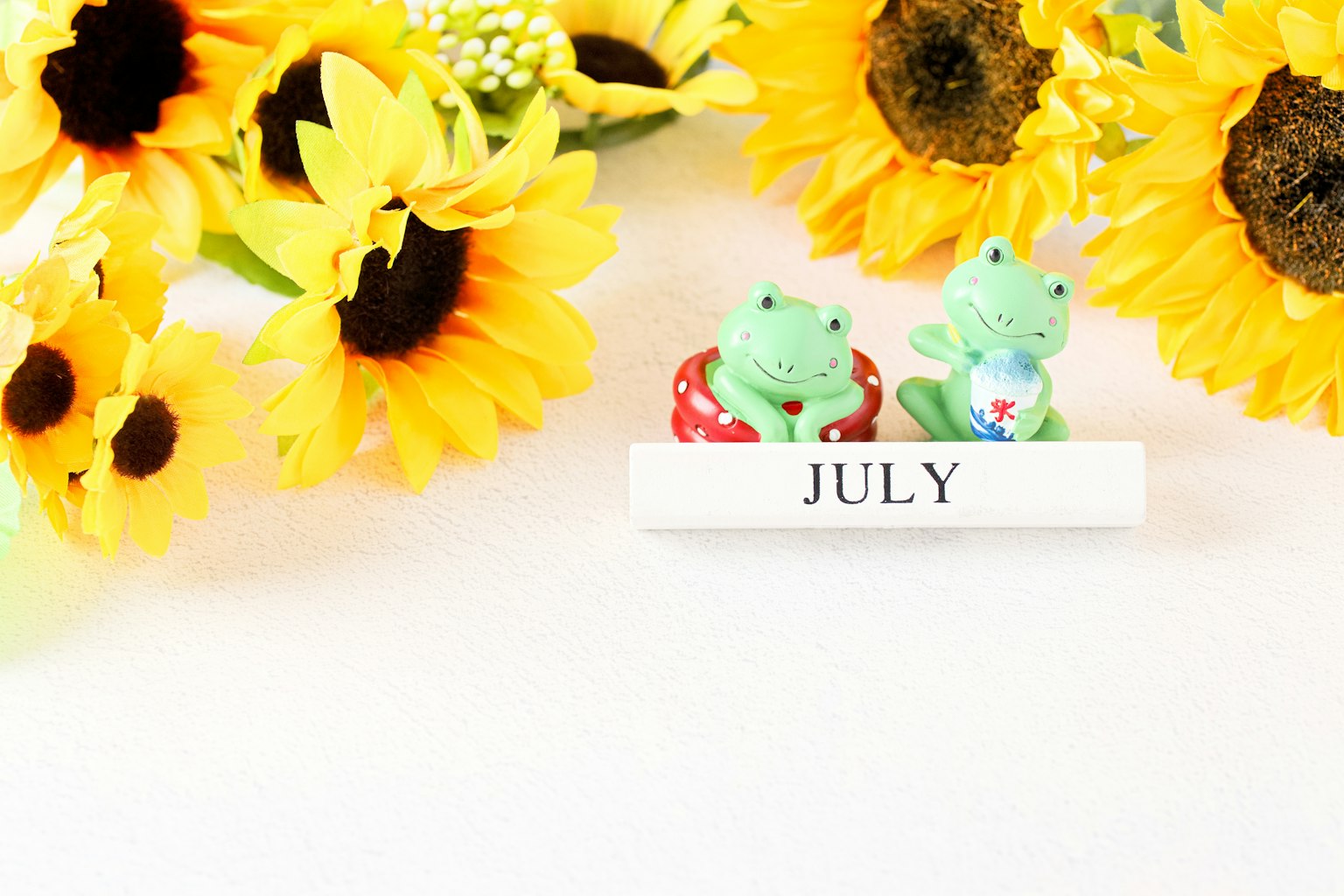 Trưng bày hoa hướng dương vàng và tượng ếch nhỏ cho tháng Bảy