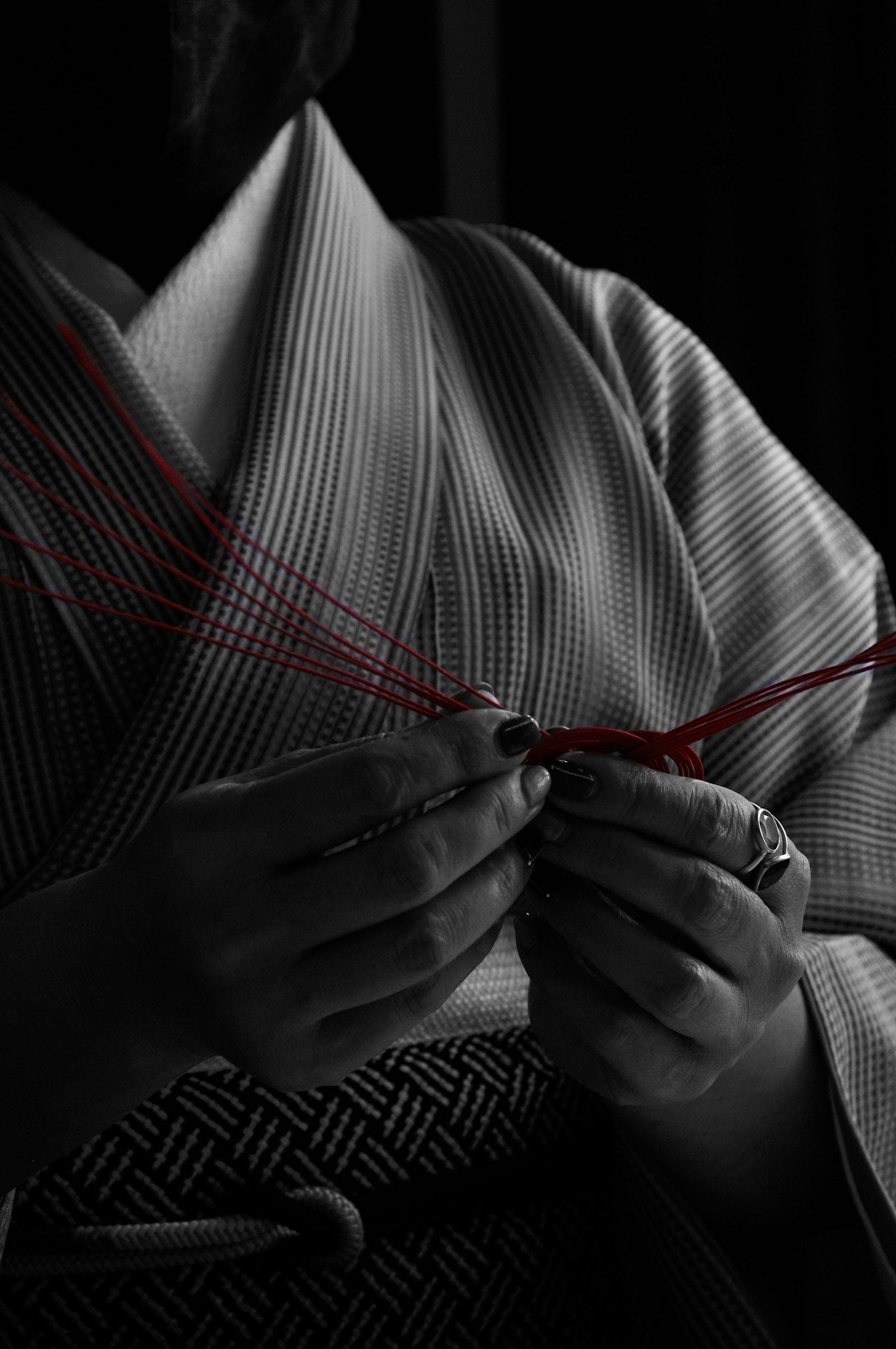 Una mujer en kimono sosteniendo hilo rojo en una foto en blanco y negro
