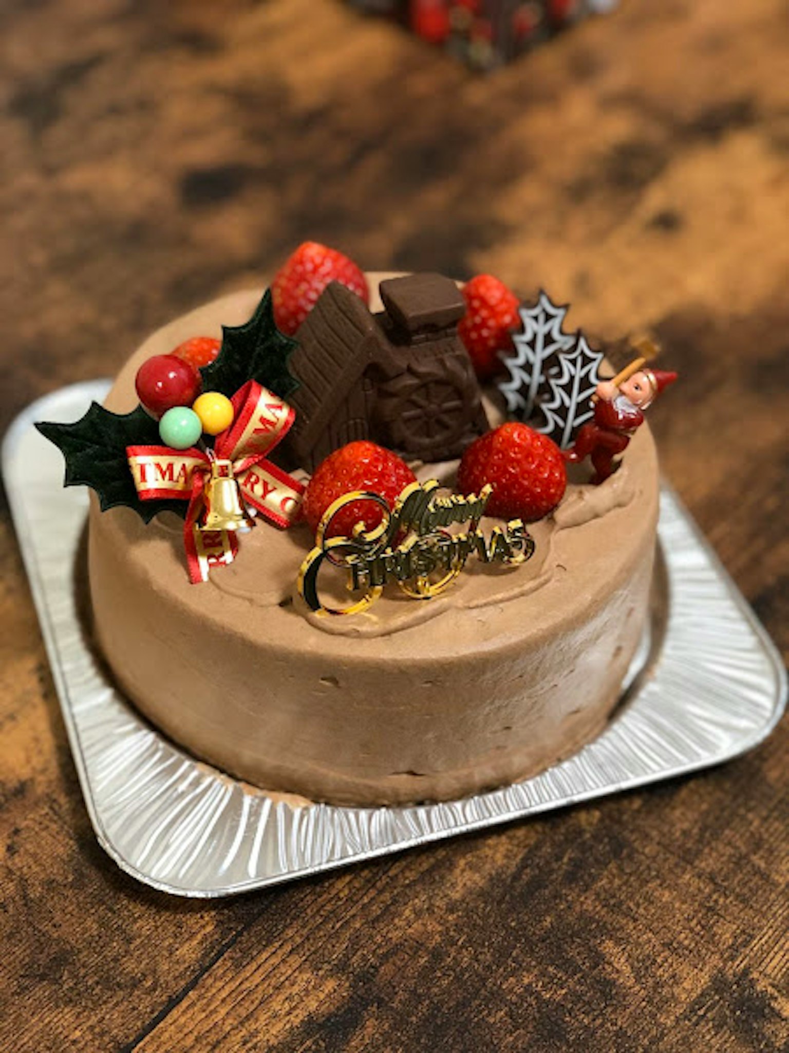 Torta di Natale decorata con fragole e decorazioni di cioccolato