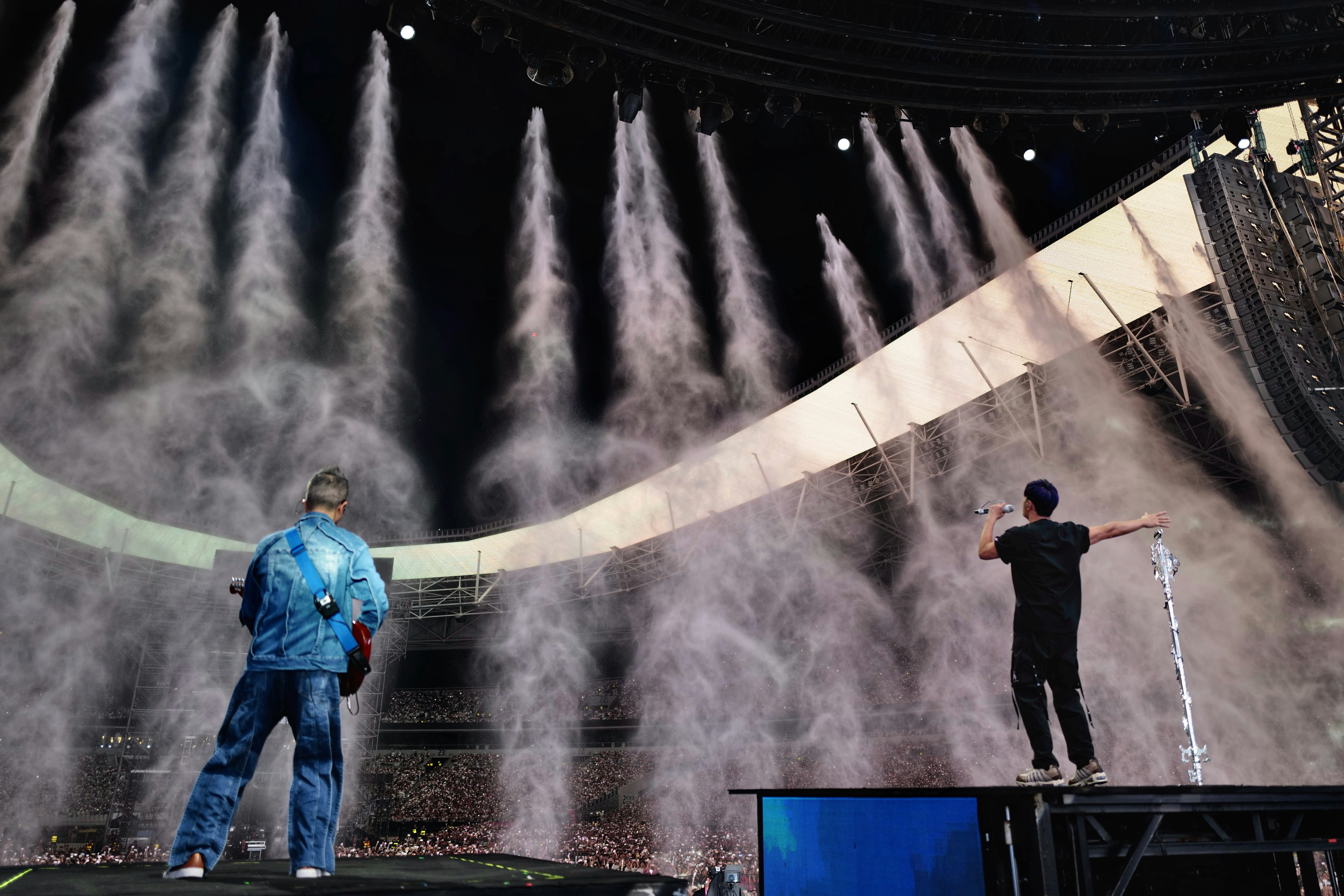 outdoor event scene with water mist jets and workers
