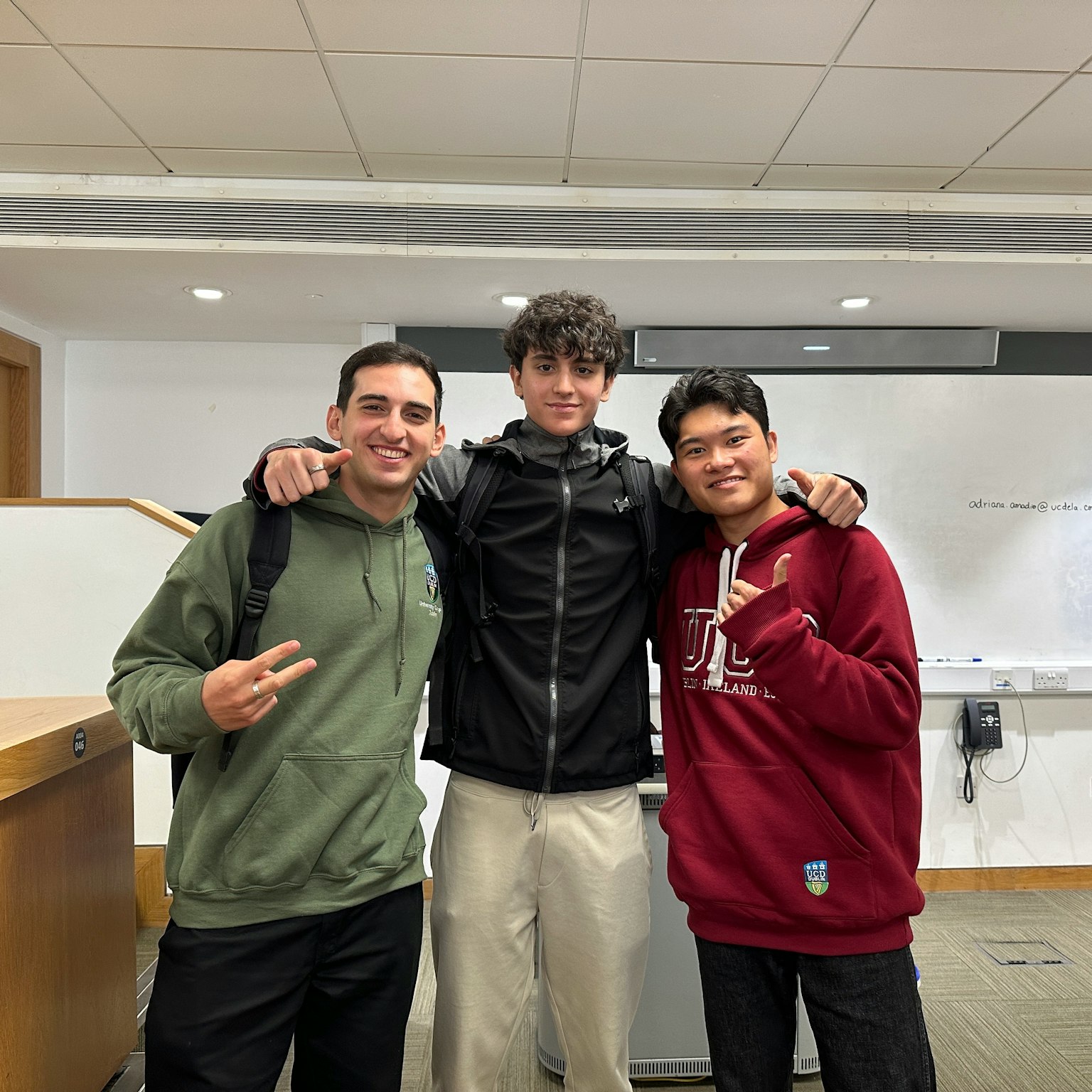 三名学生在教室里摆姿势的照片