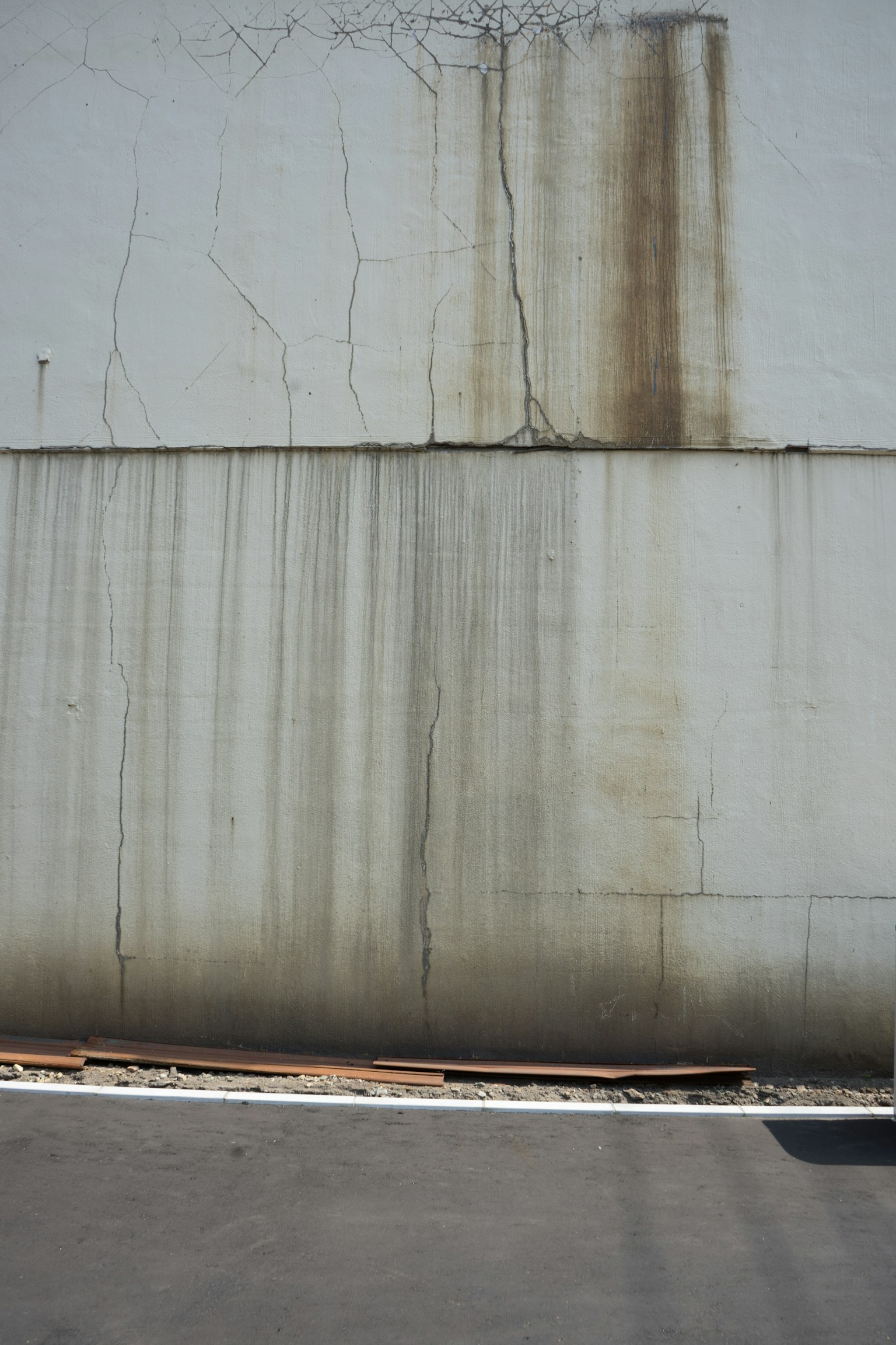 Pared blanca con manchas de agua marrones y grietas