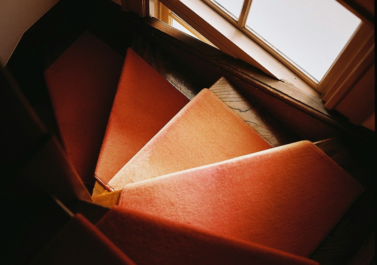 Vista di una scala a chiocciola con gradini in moquette rossa