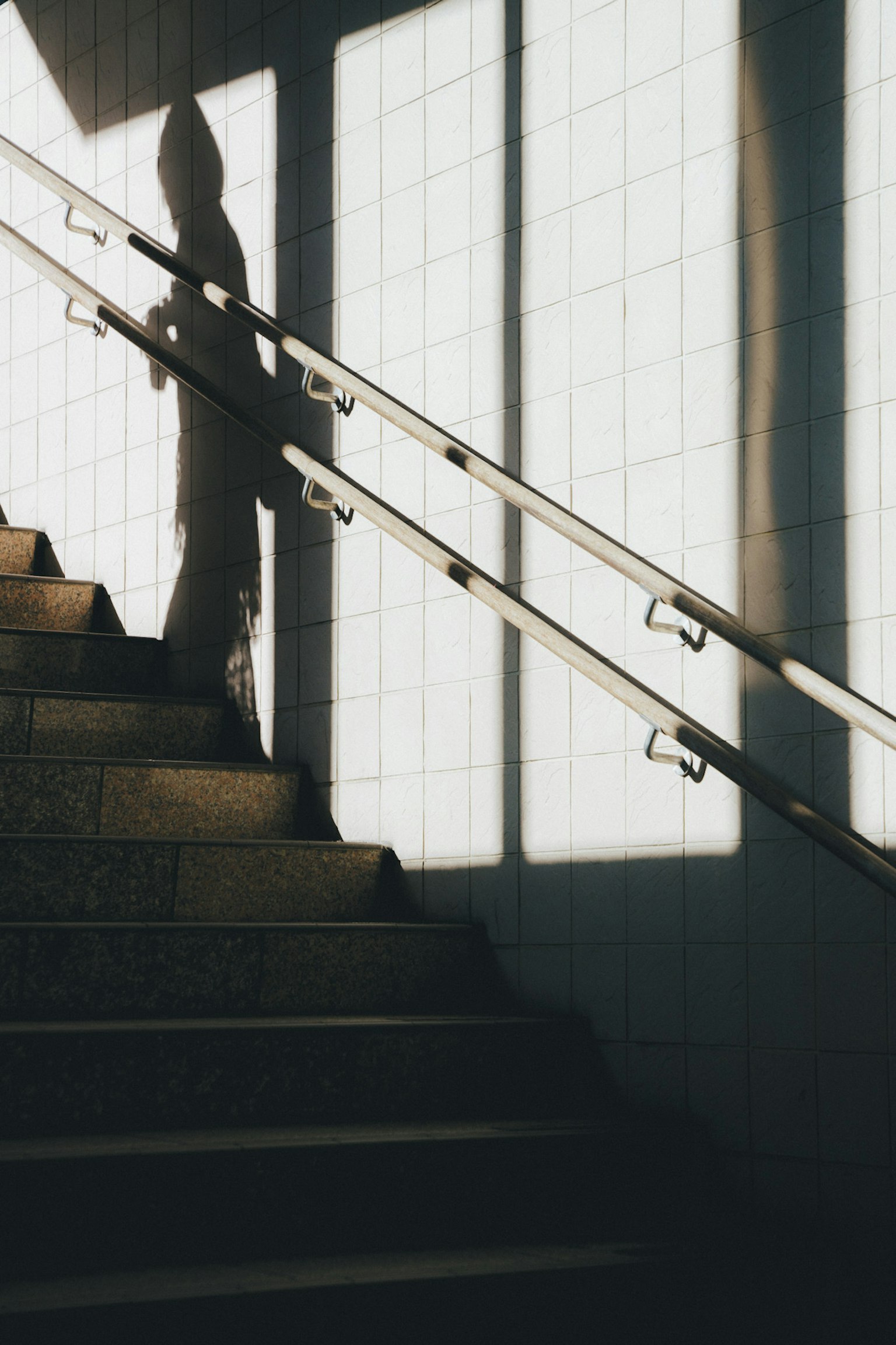 Ombre d'une personne montant des escaliers avec des motifs de lumière