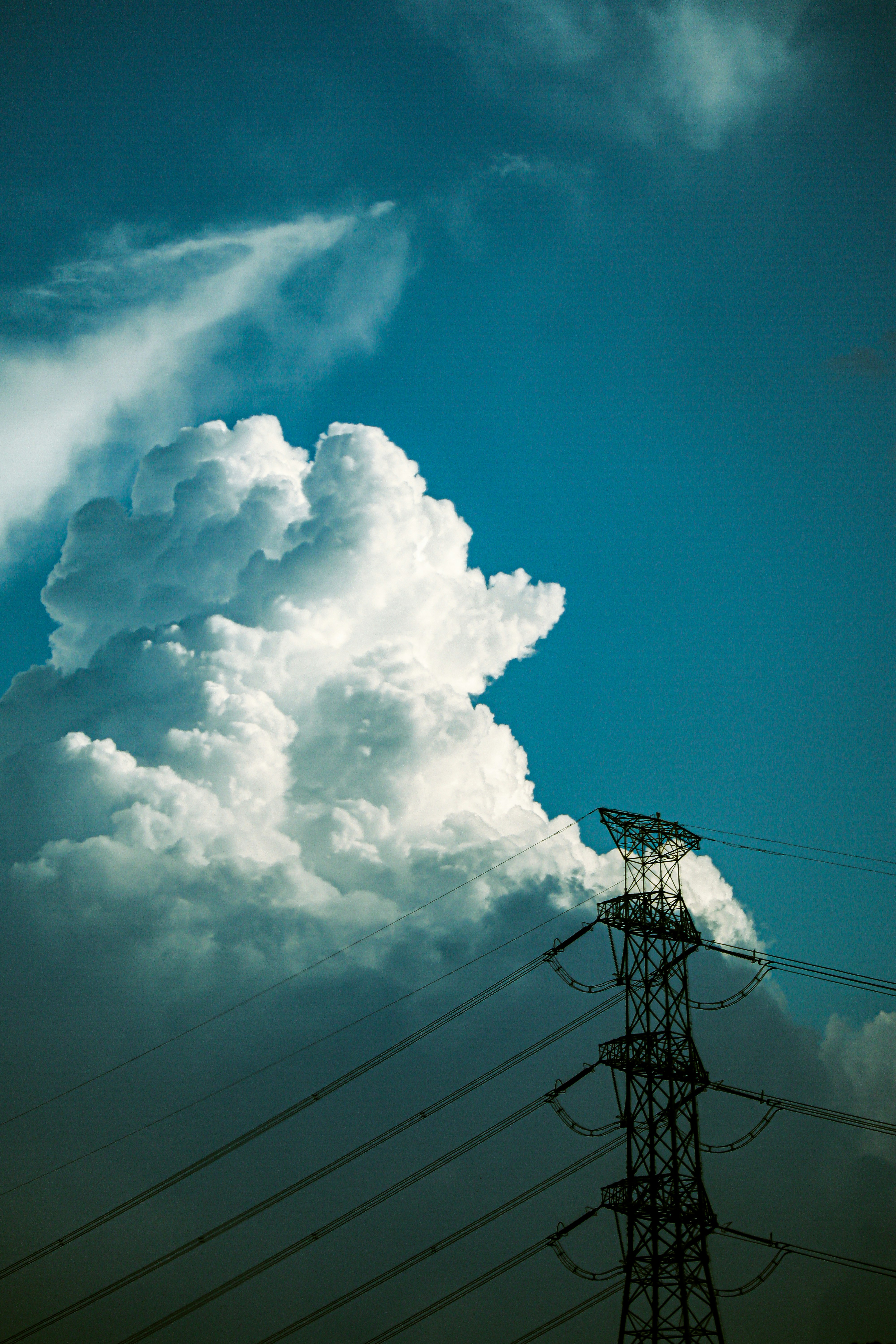 入道雲と鉄塔が並ぶ夏の空の風景