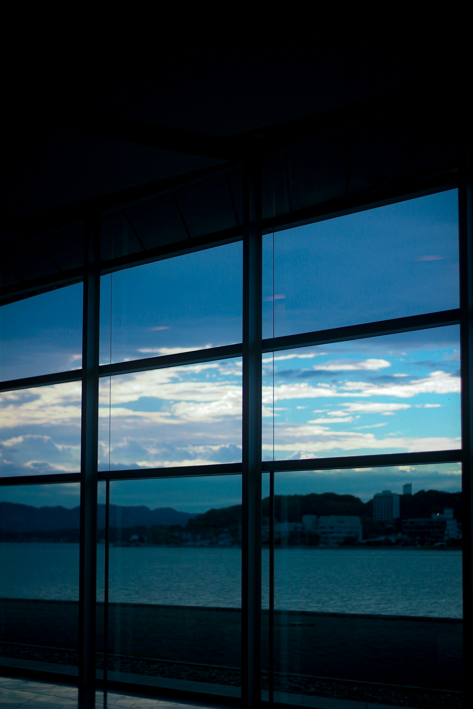 Large window reflecting blue sky and clouds