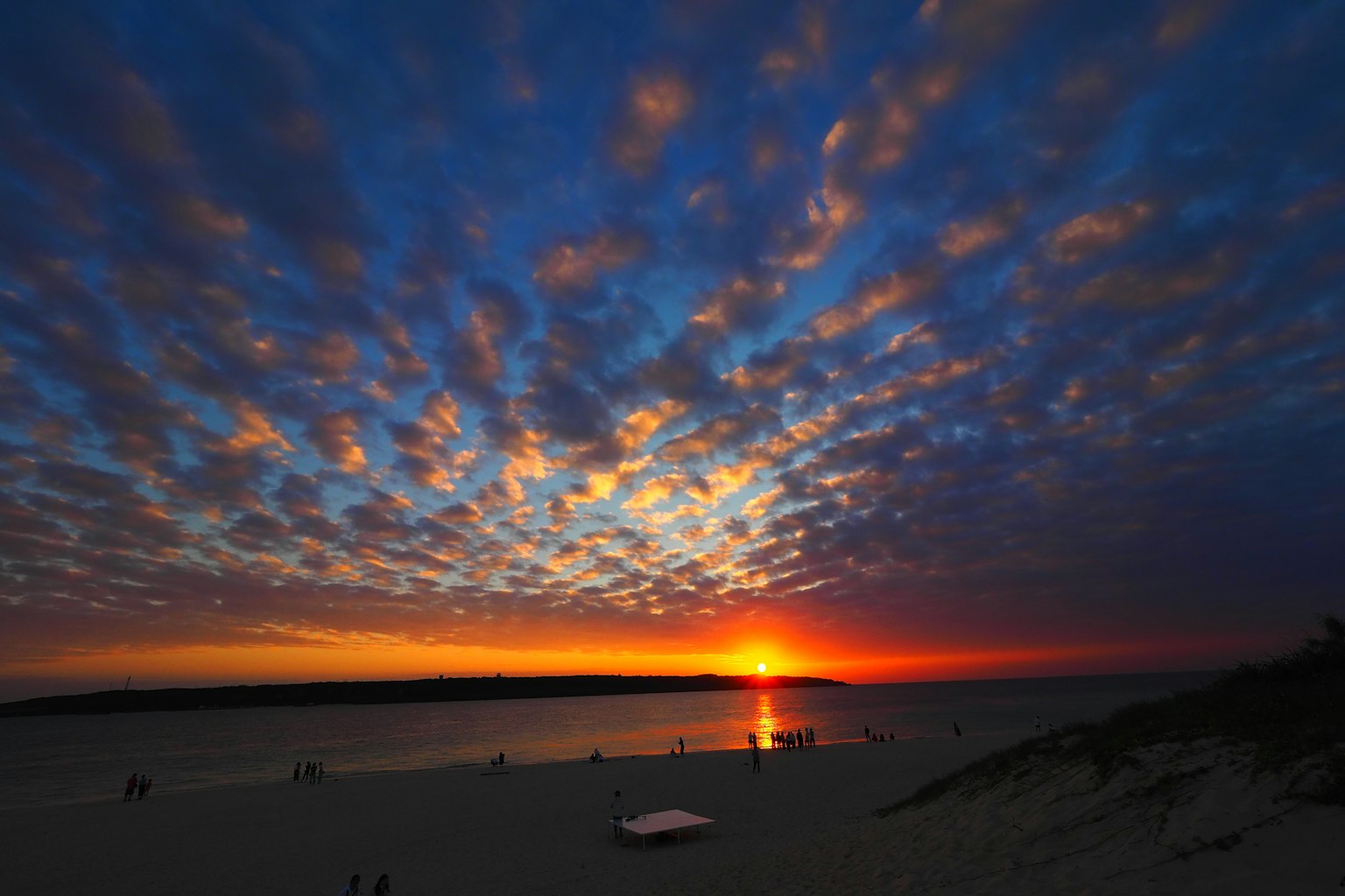Scène de coucher de soleil sur la plage avec des nuages colorés dans le ciel