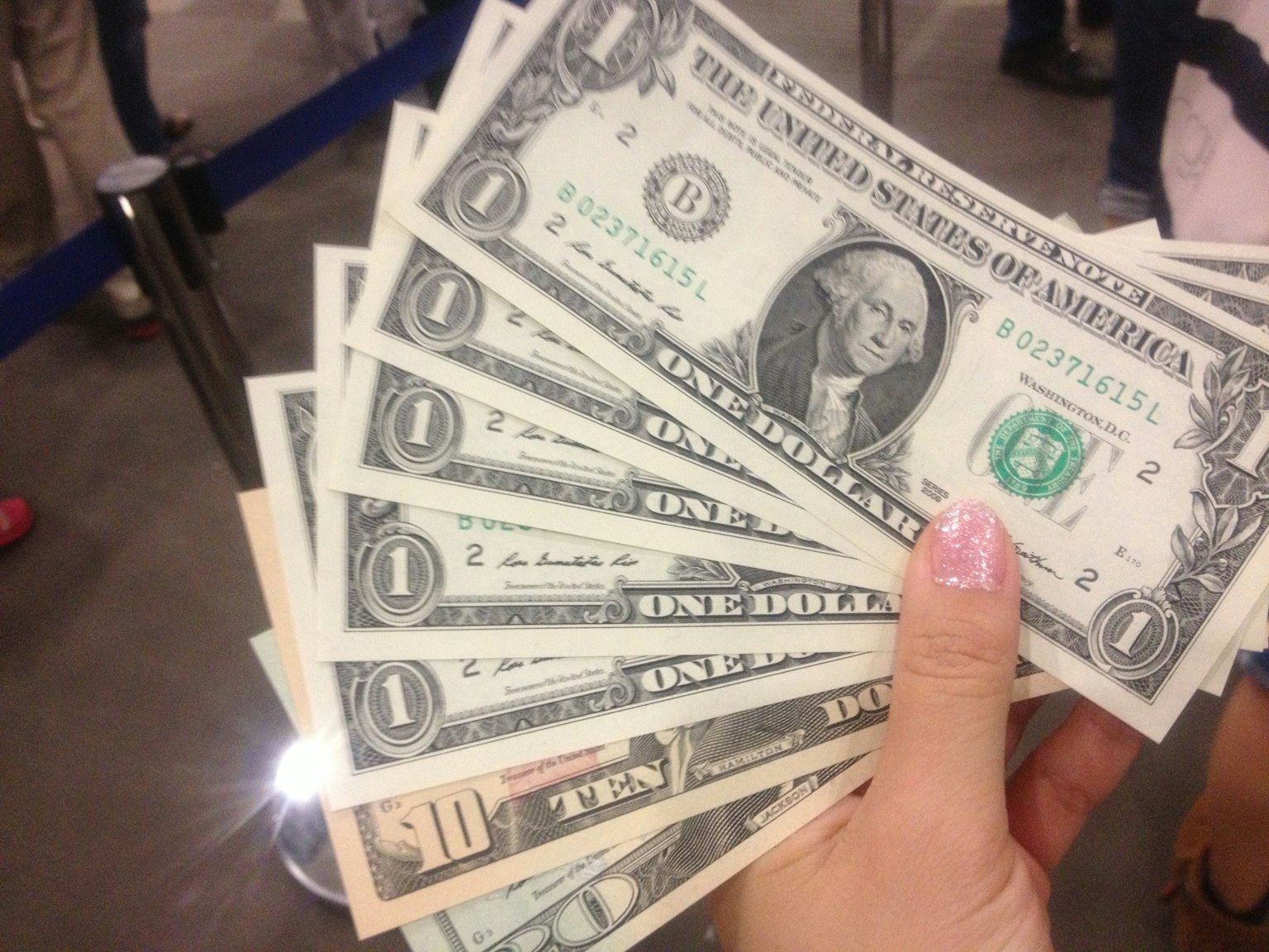 Un paquet de billets d'un dollar américain tenu dans une main