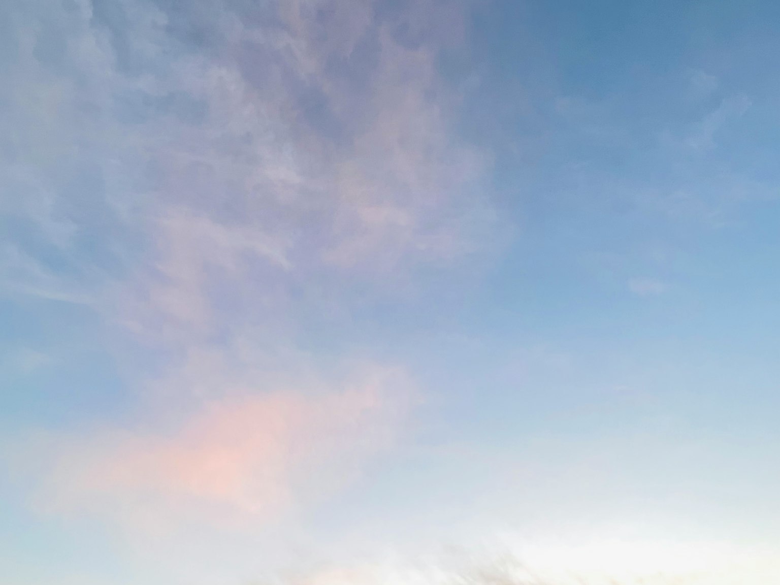 Langit tenang dengan awan lembut dalam nuansa biru dan merah muda