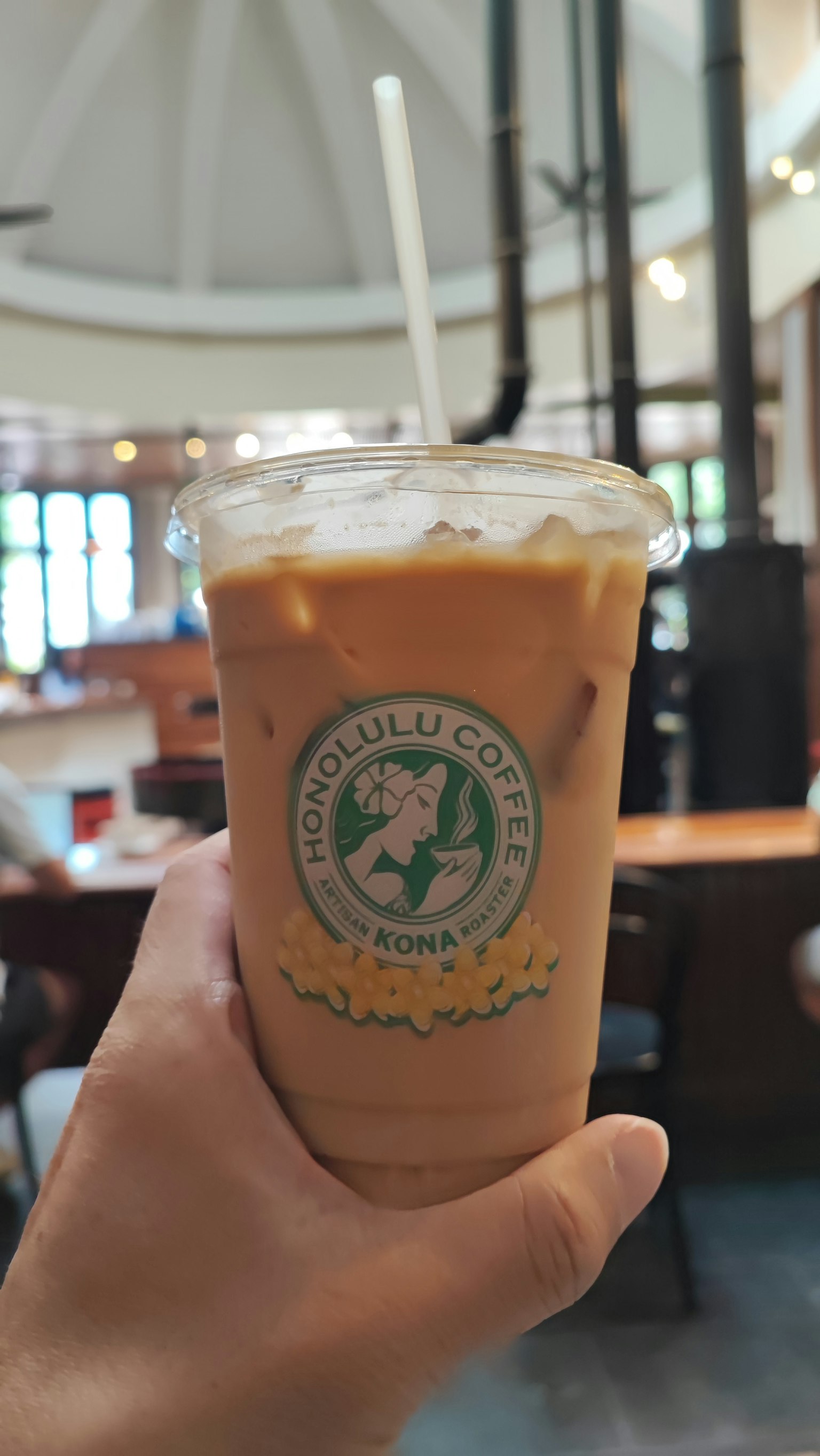 มือถือกาแฟเย็นในภายในร้านกาแฟ