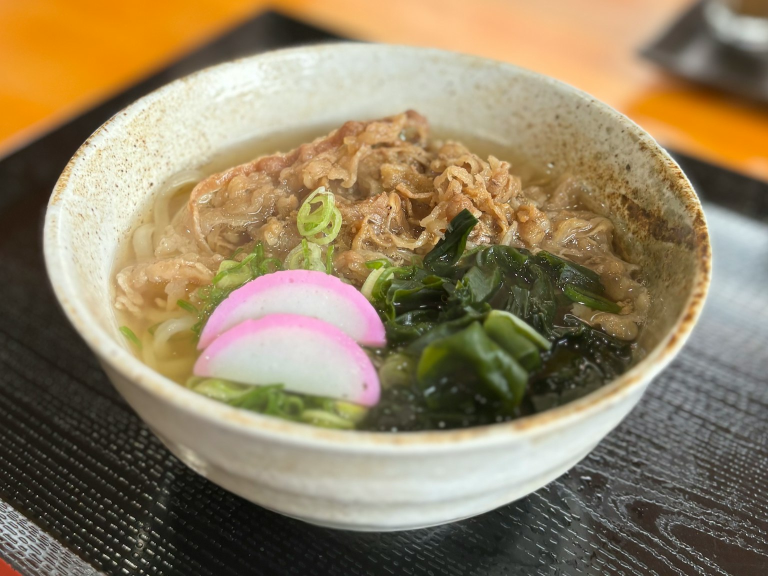 Mangkok ramen yang indah dengan kaldu, daging, daun bawang, rumput laut, dan kamaboko