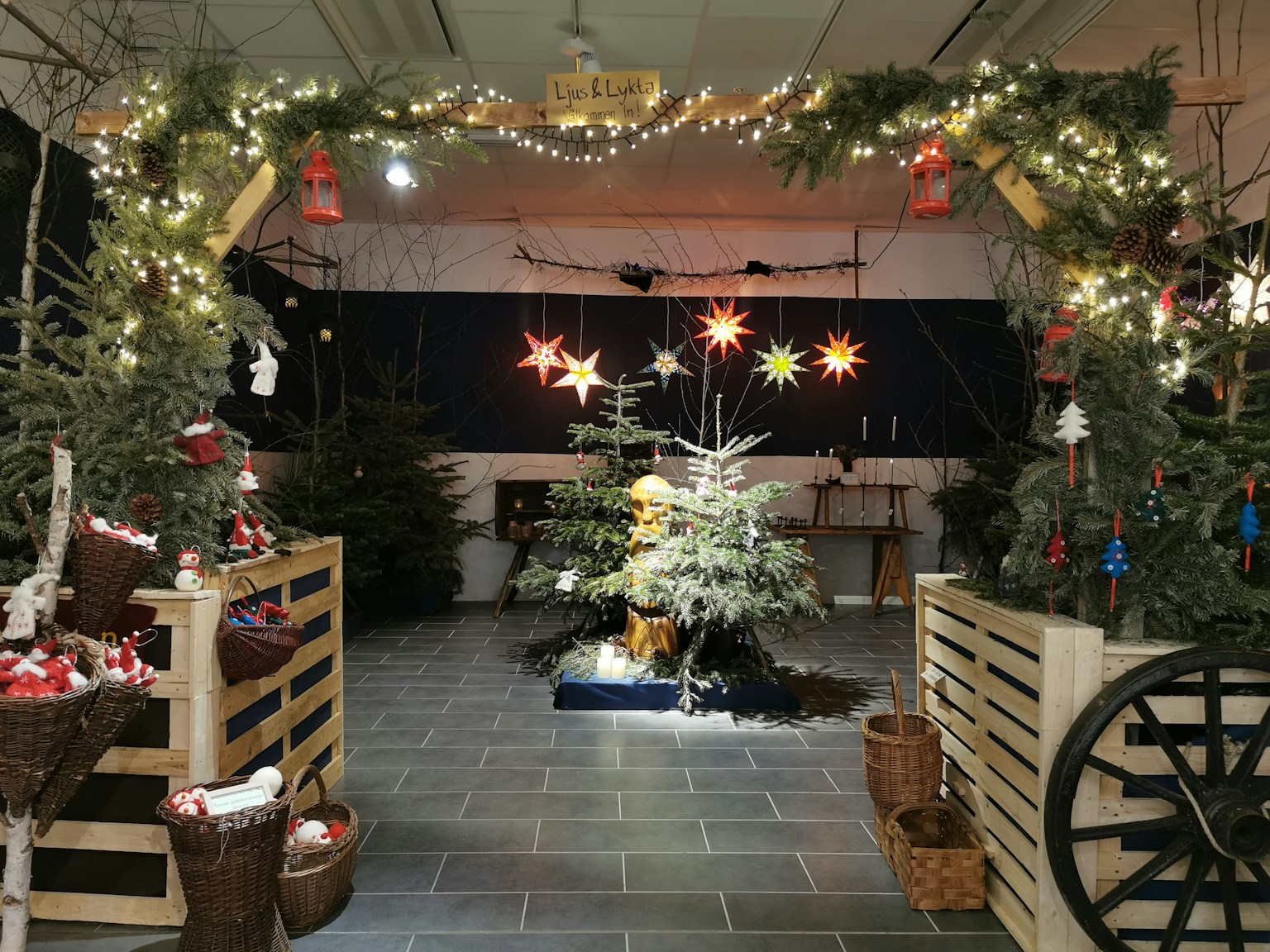 Entrada decorada para Navidad con un árbol de Navidad de madera y adornos en forma de estrella