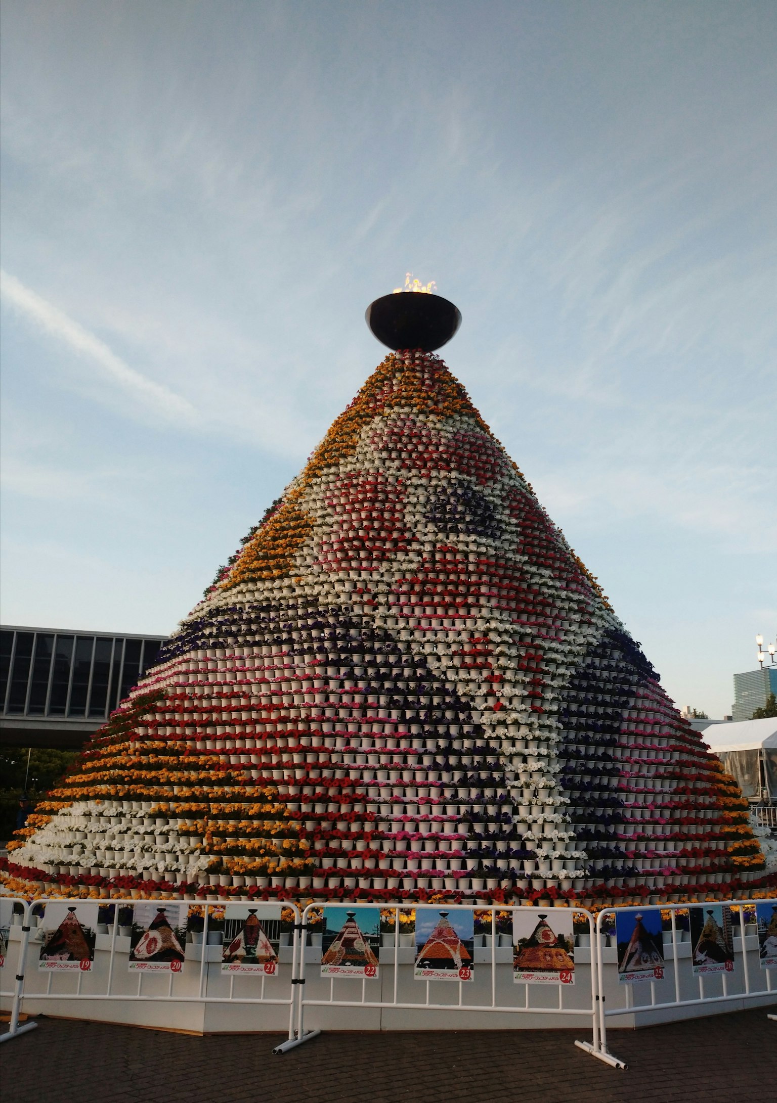 Grande structure conique faite de tasses colorées sous un ciel dégagé