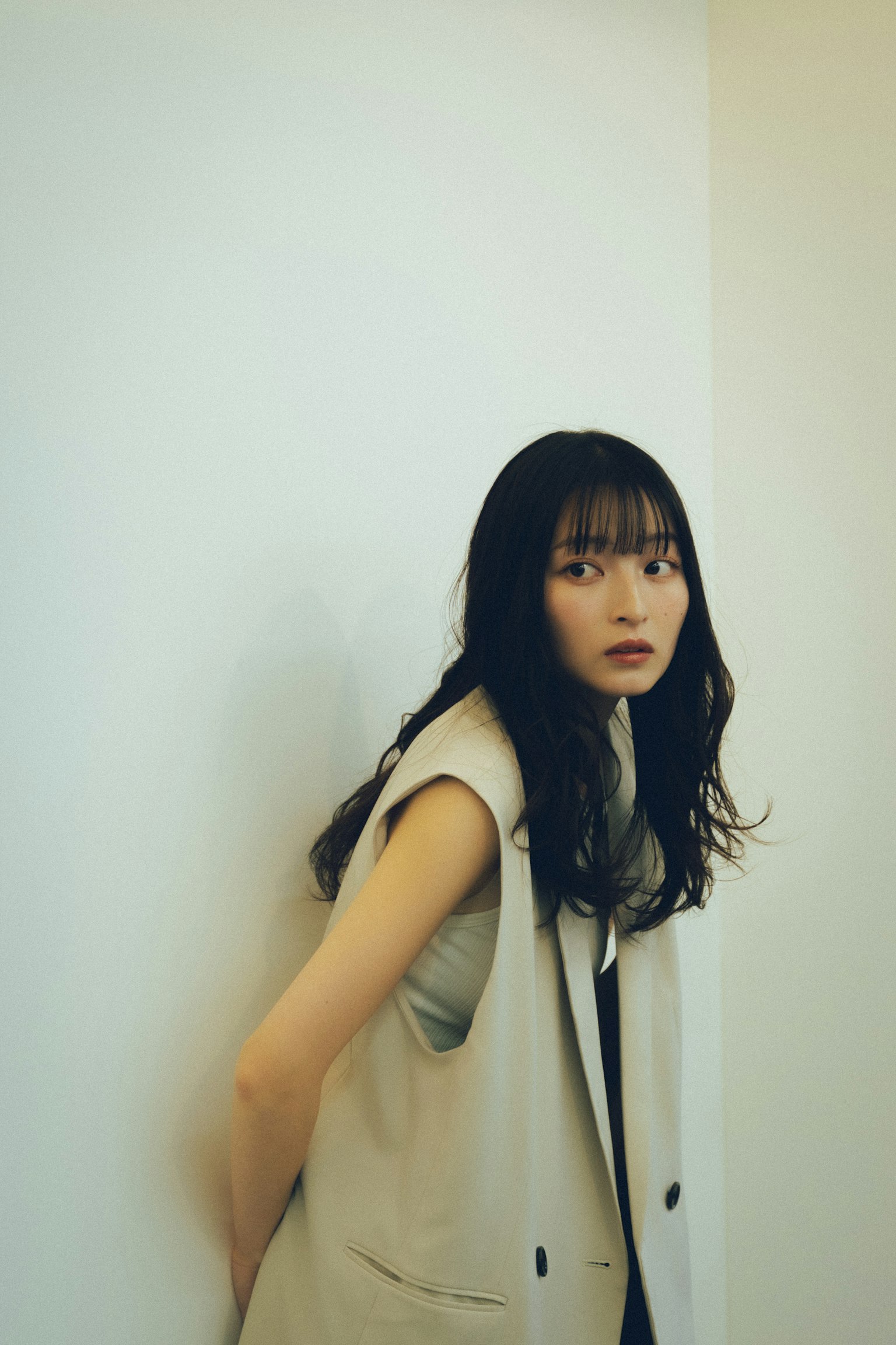 靠在墙上的女性肖像 拥有长发和休闲服装