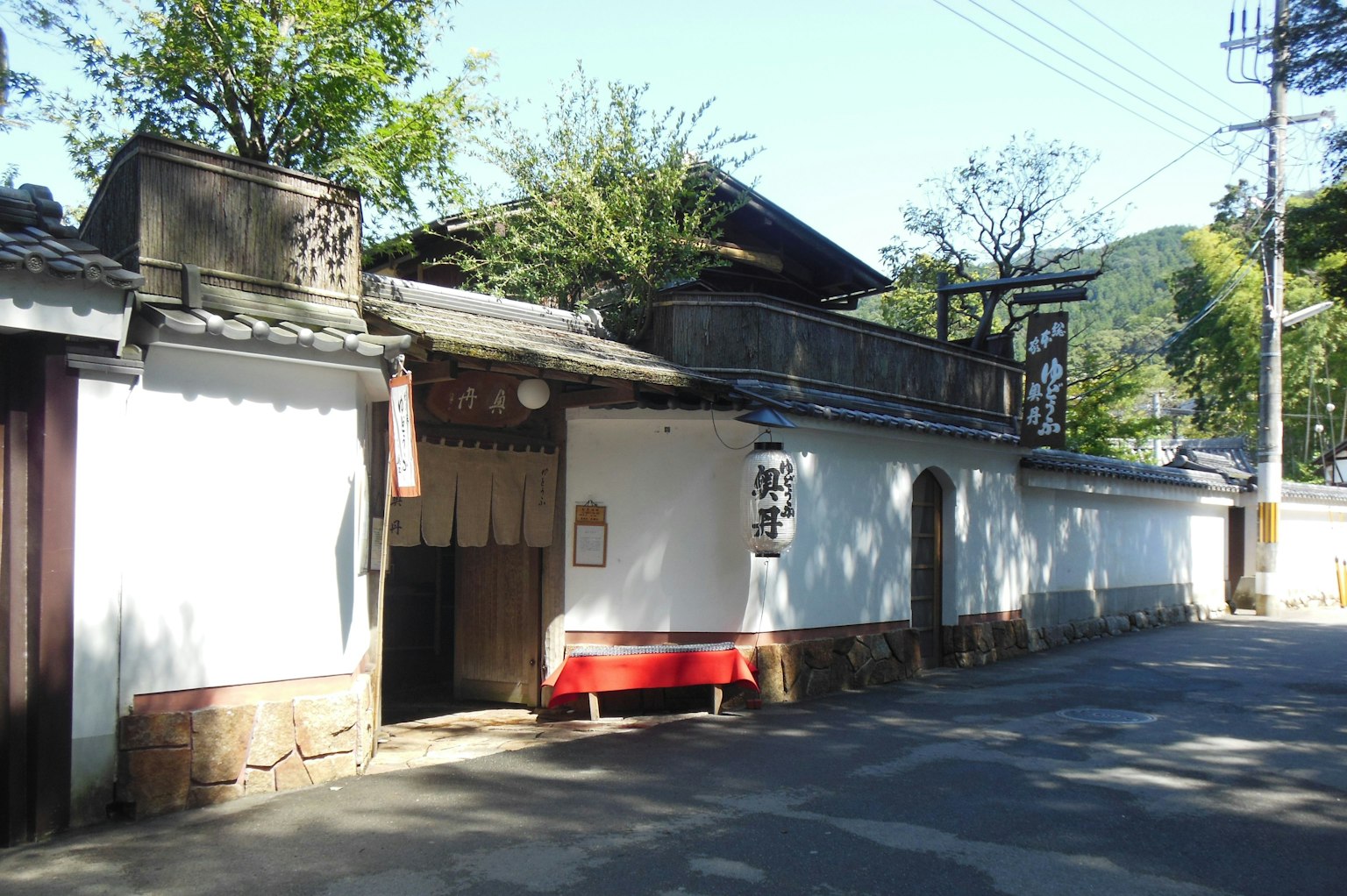 Extérieur d'une maison japonaise traditionnelle avec des murs blancs et un toit en bois
