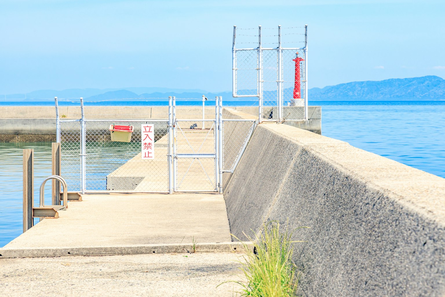 Muelle de concreto con fondo de mar azul y cielo brillante