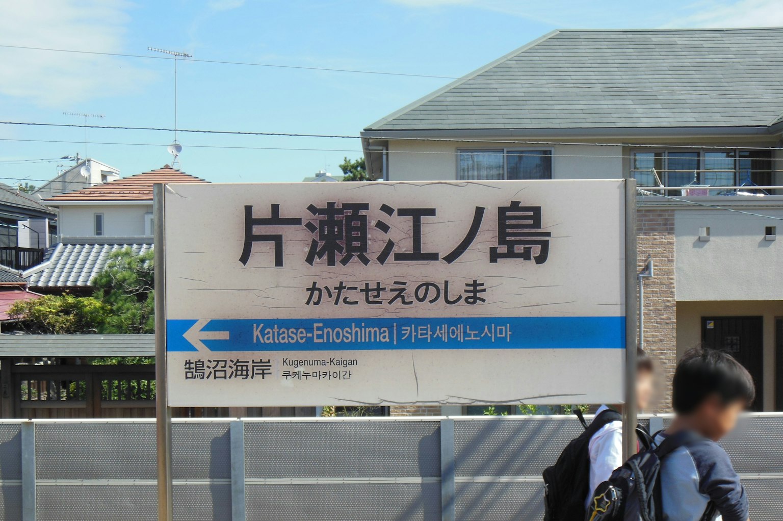 Panneau de la station Katase-Enoshima avec des maisons environnantes