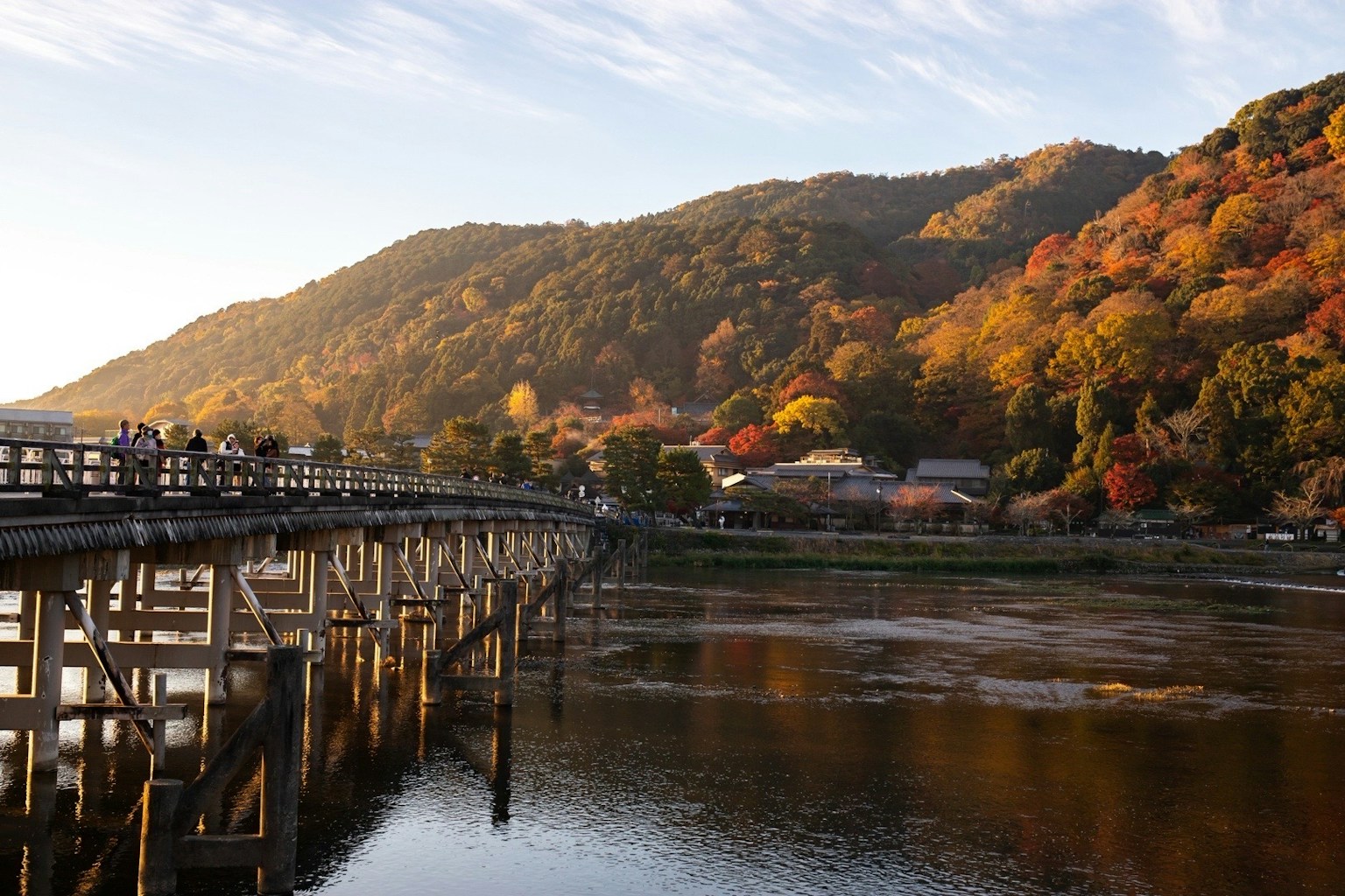 Scenic view of a wooden bridge with autumn foliage and mountains