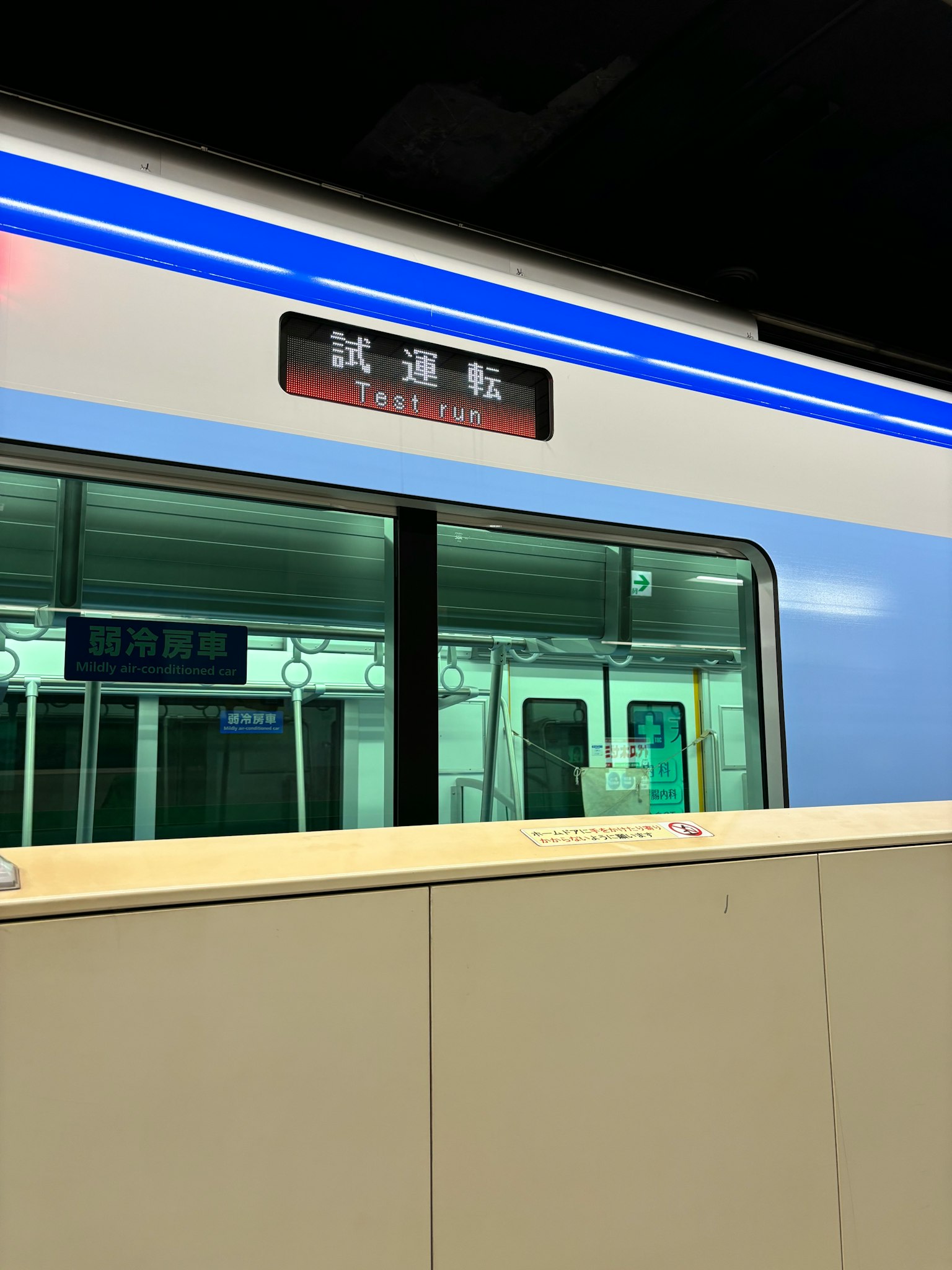 Pemandangan kereta bawah tanah malam dengan jendela kereta biru dan tampilan nama stasiun
