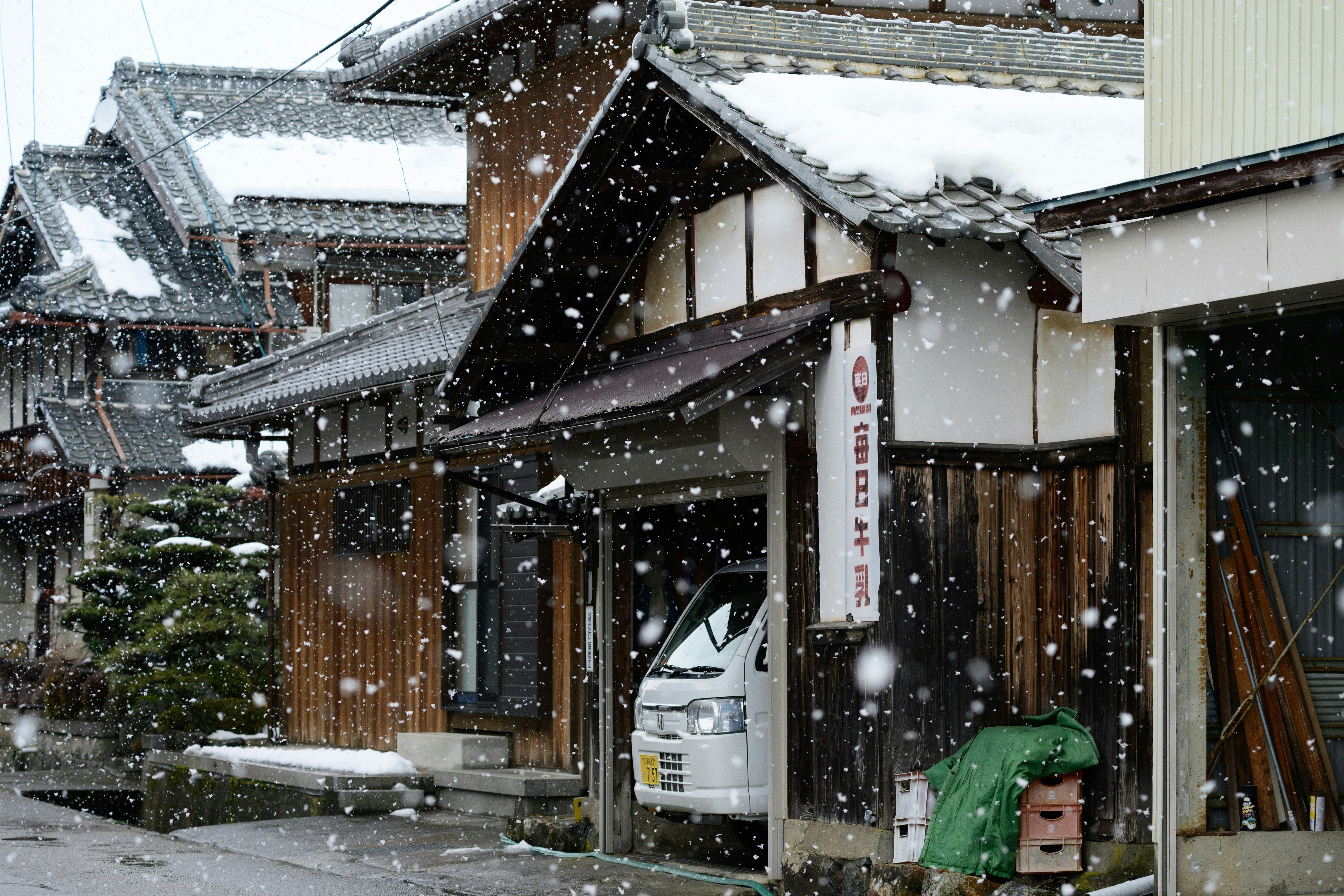 Maisons traditionnelles japonaises avec avant-toits sous la neige « botan »