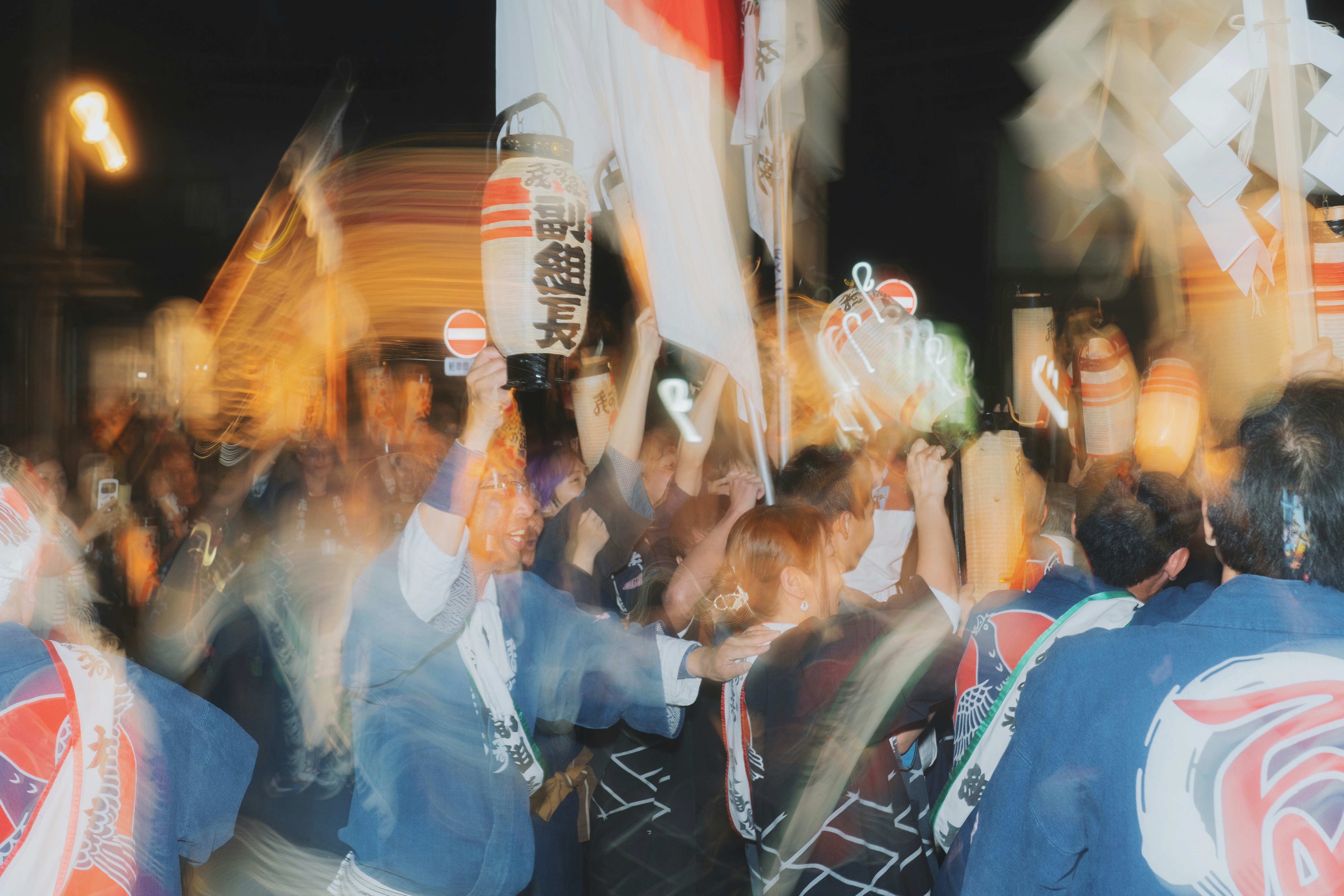 crowd waving and illuminated banners in a night street