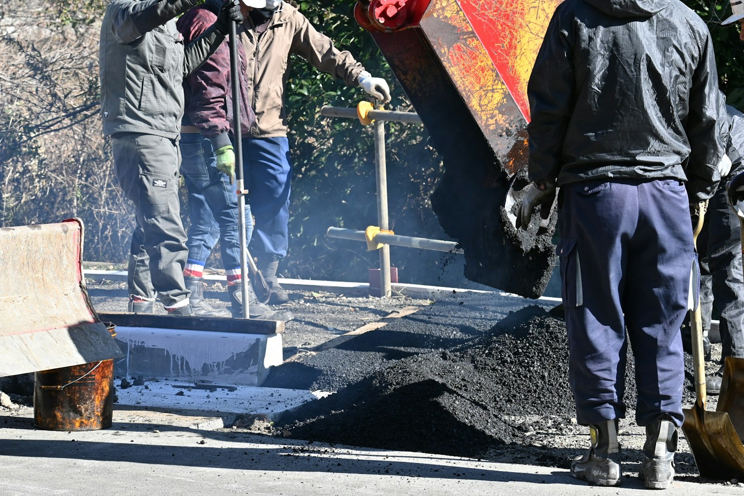 Workers pouring asphalt at a construction site