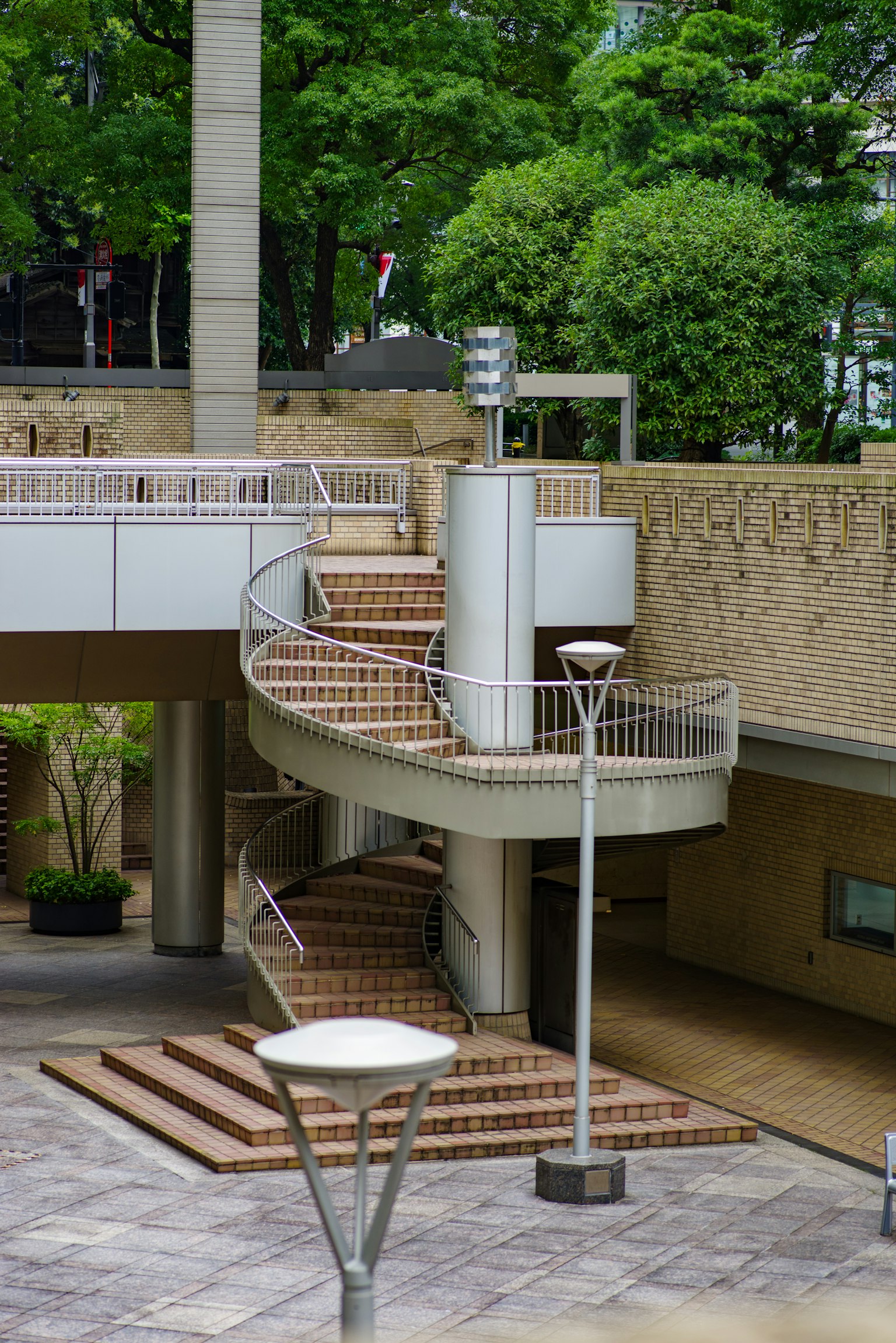 Extérieur de bâtiment moderne avec escalier courbe et arbres verts