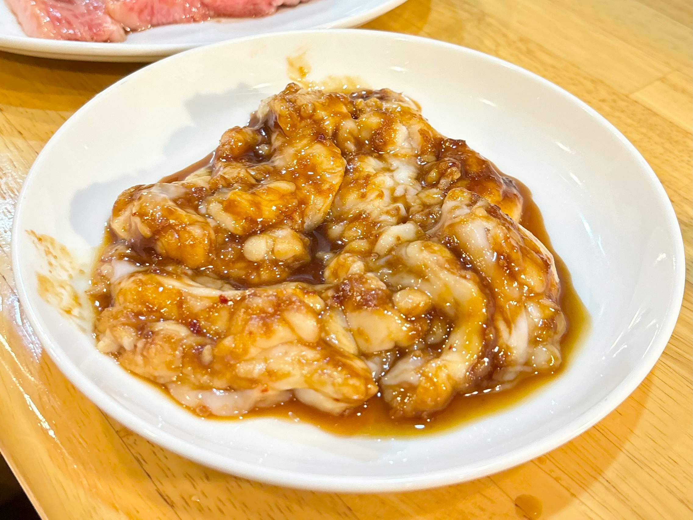 Piatto di carne in stile teriyaki servito in un piatto su un tavolo di legno