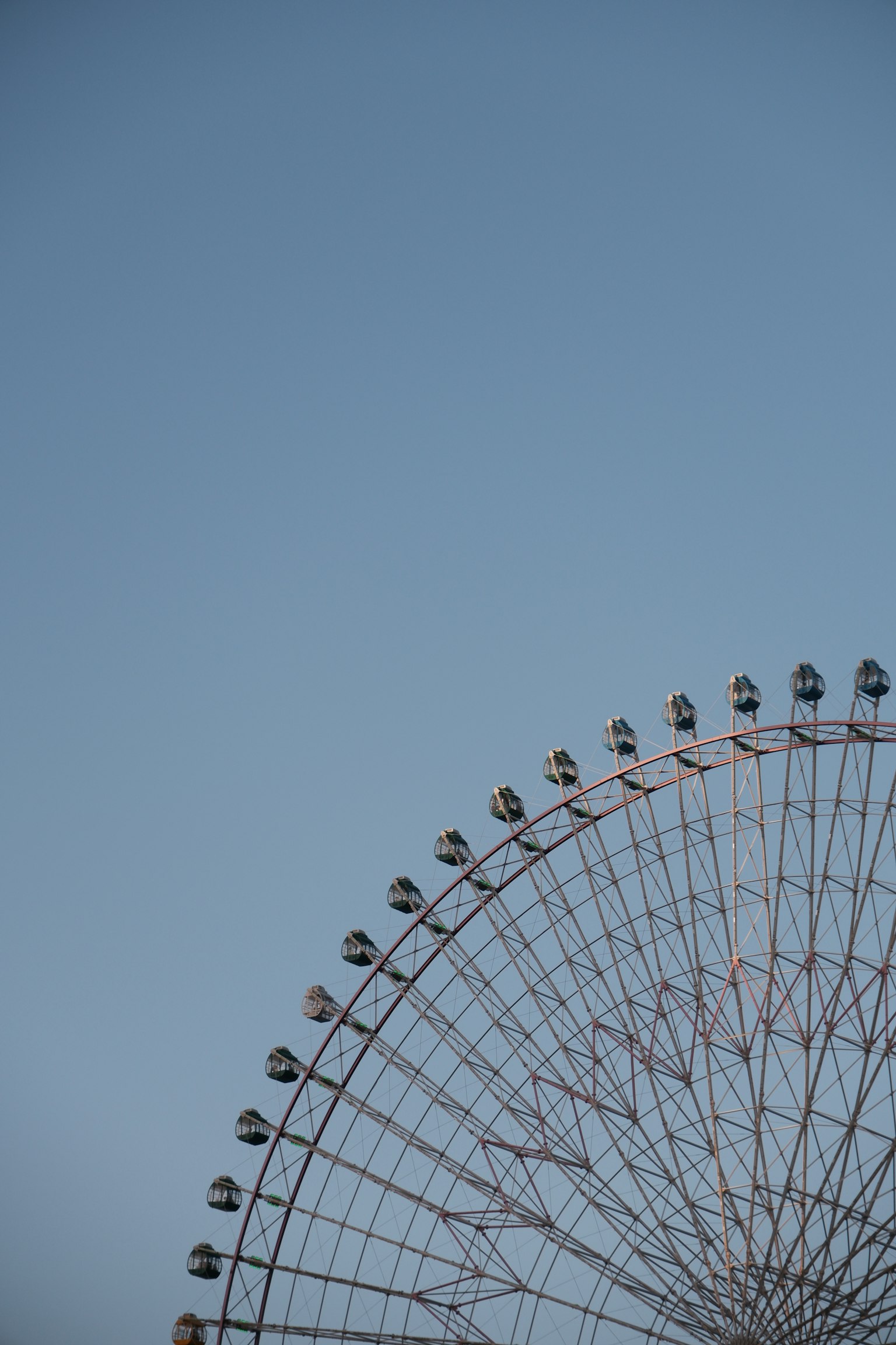 Parte di una ruota panoramica contro un cielo blu
